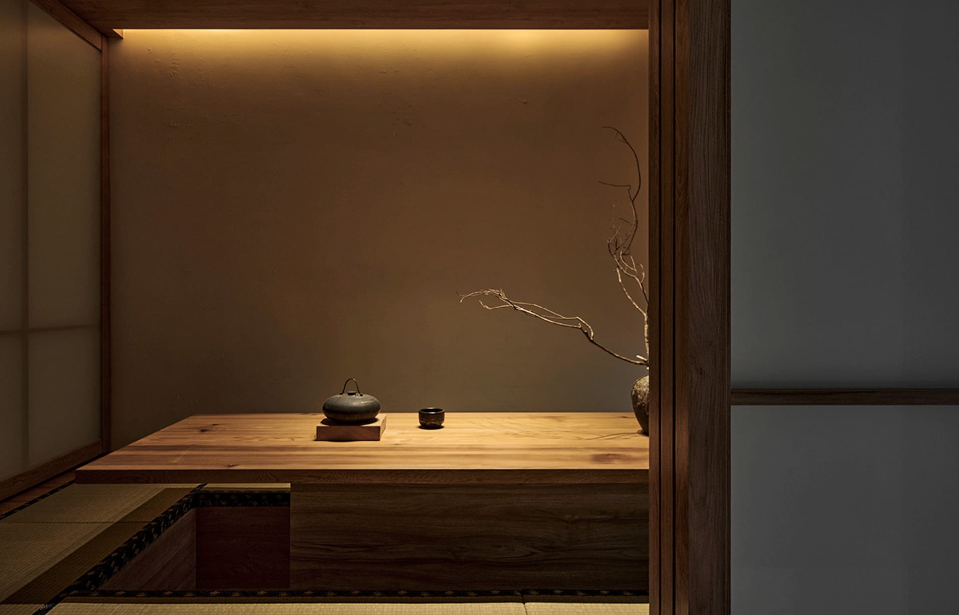 Minimalist coffee table made of wood with a vase and a cup on it.