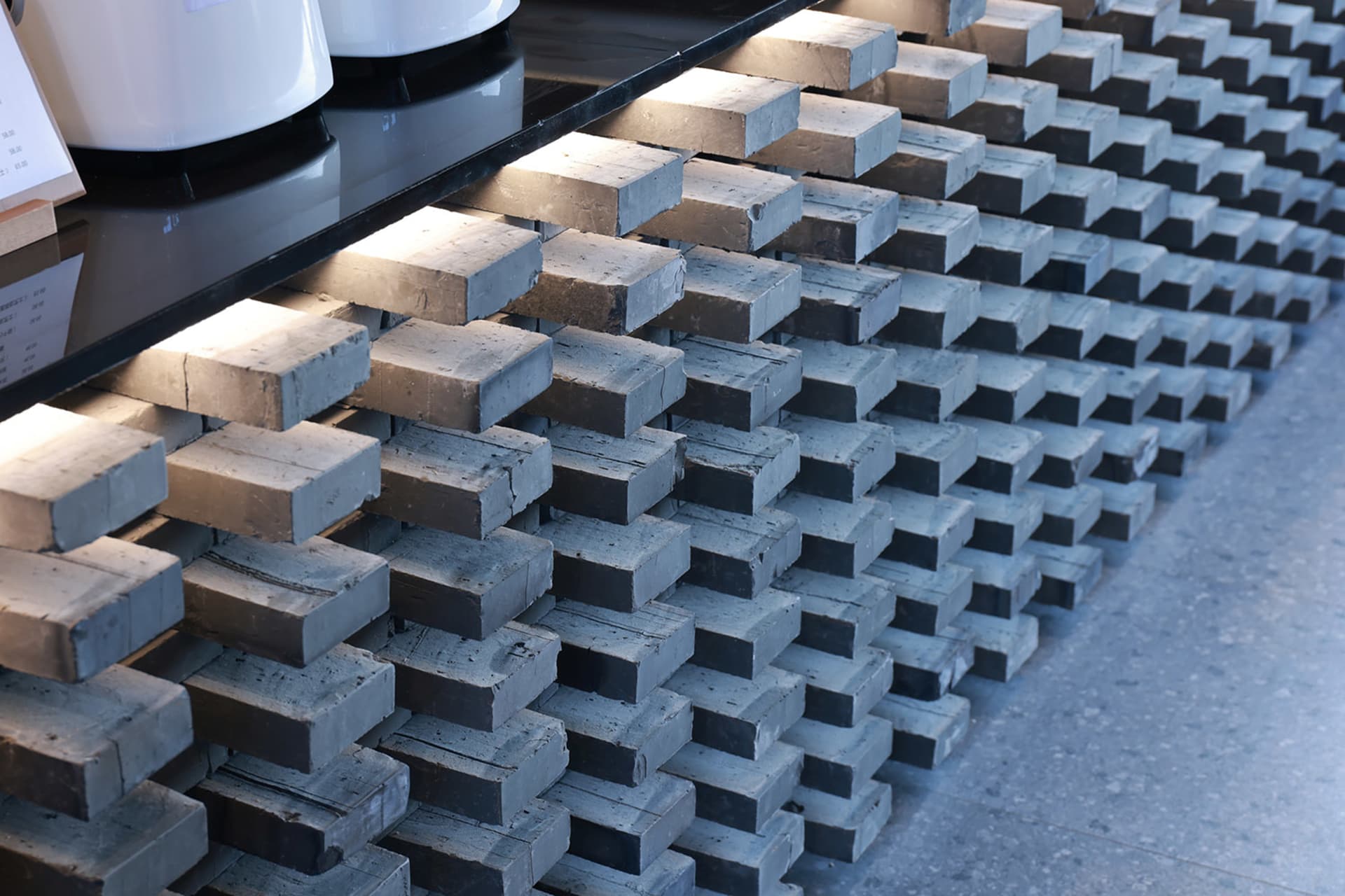 Organized arrangement of gray and brown rectangular concrete plates in an architectural setting.