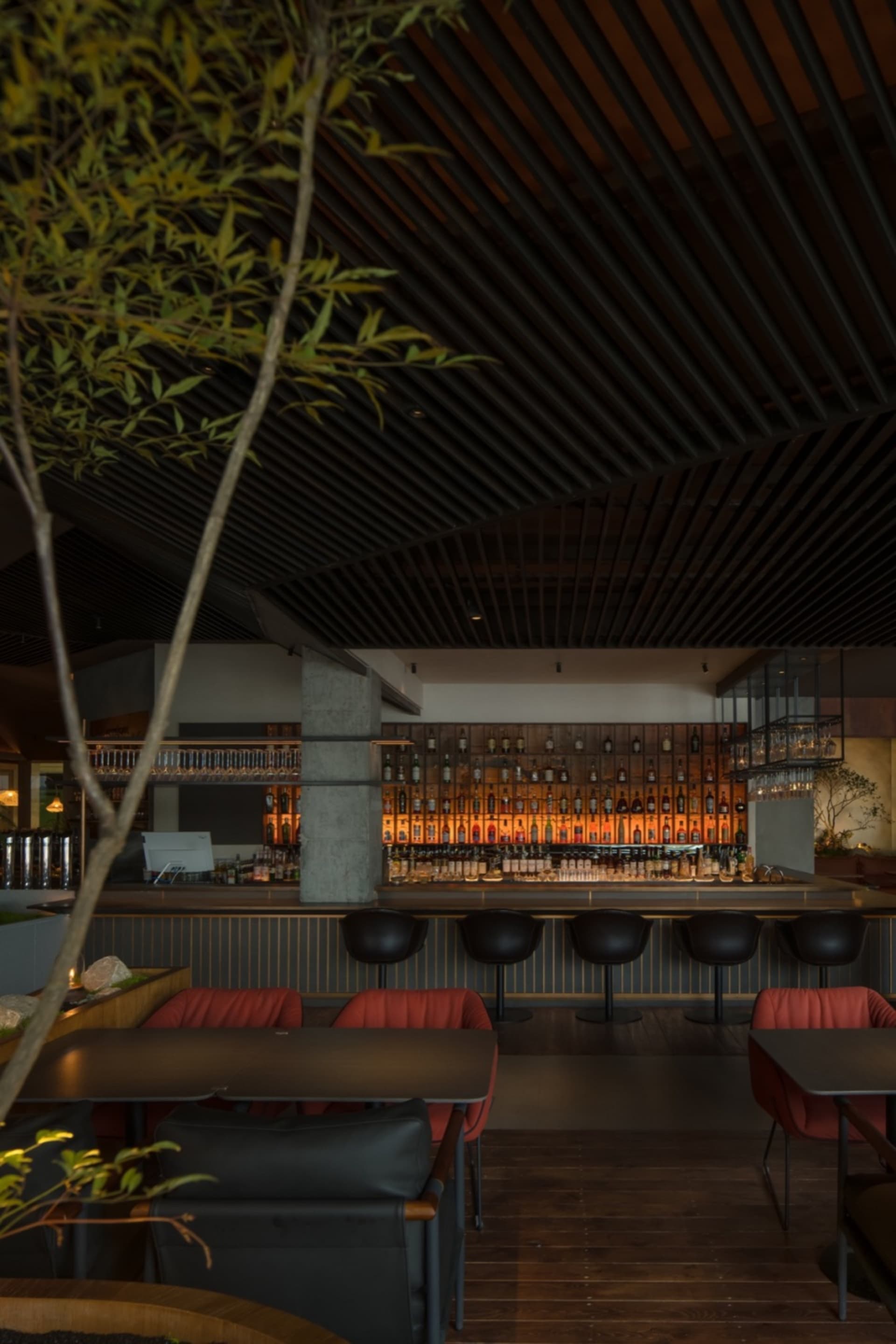 Modern restaurant bar interior with wood, concrete, and metal elements