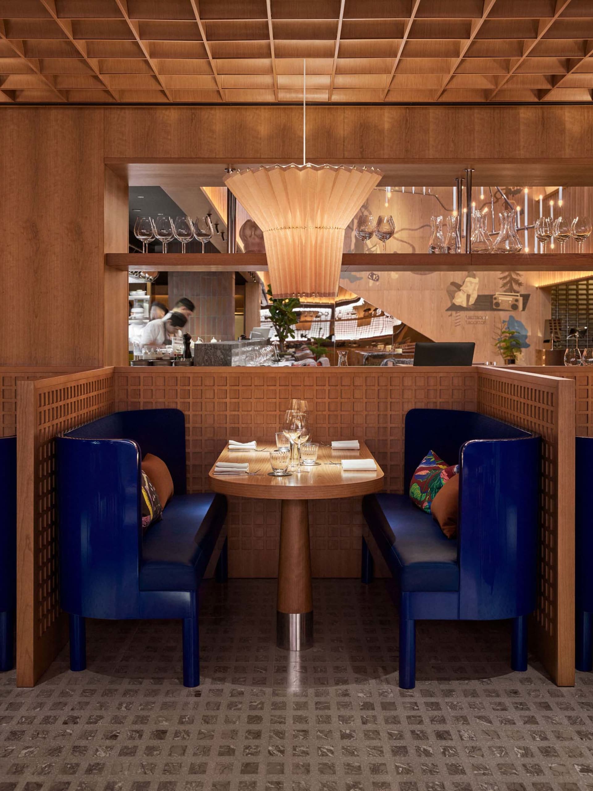 A cozy restaurant interior with modern blue booths and wooden accents.