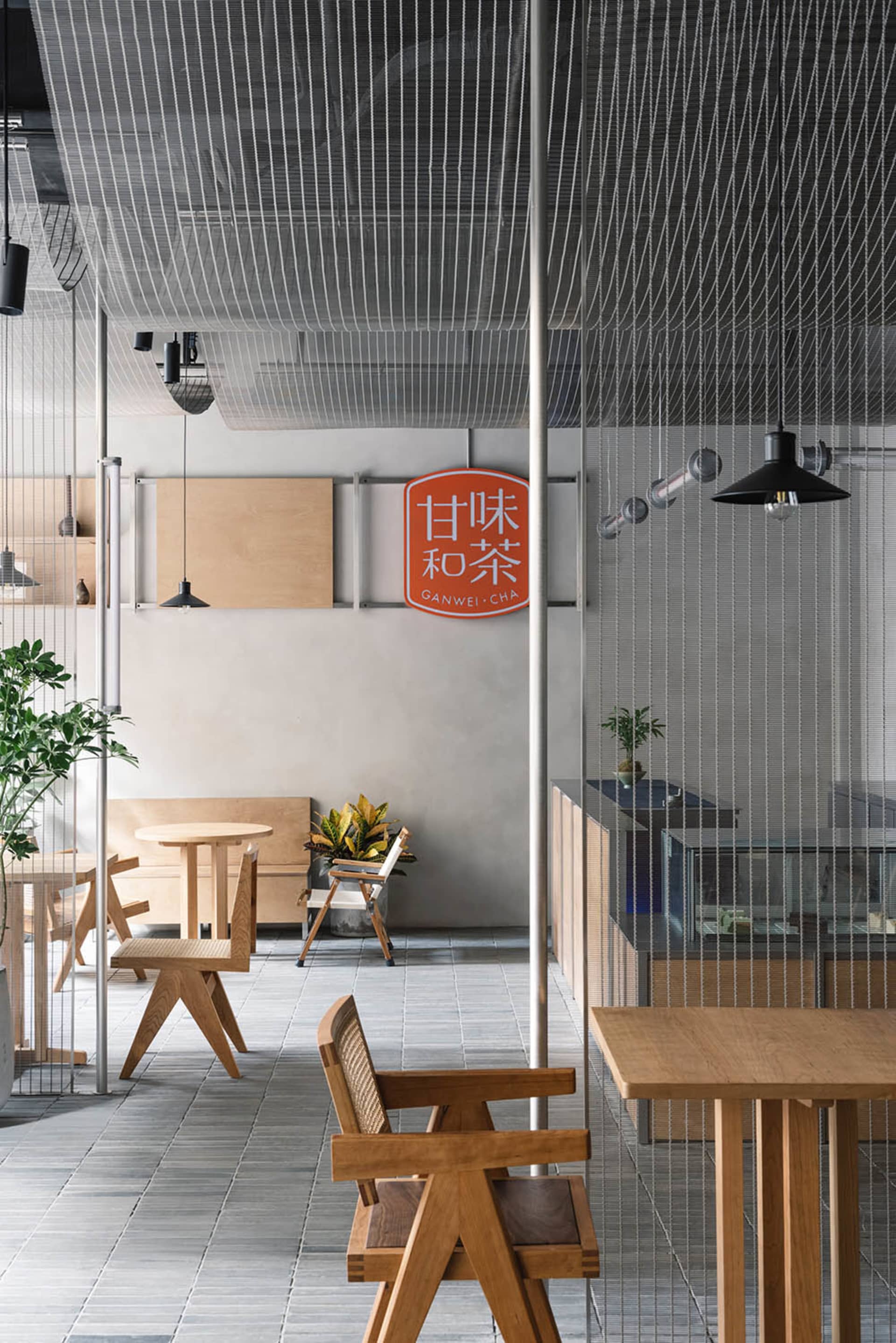 簡約餐廳室內,配有木質家具、現代燈光與綠色植物。