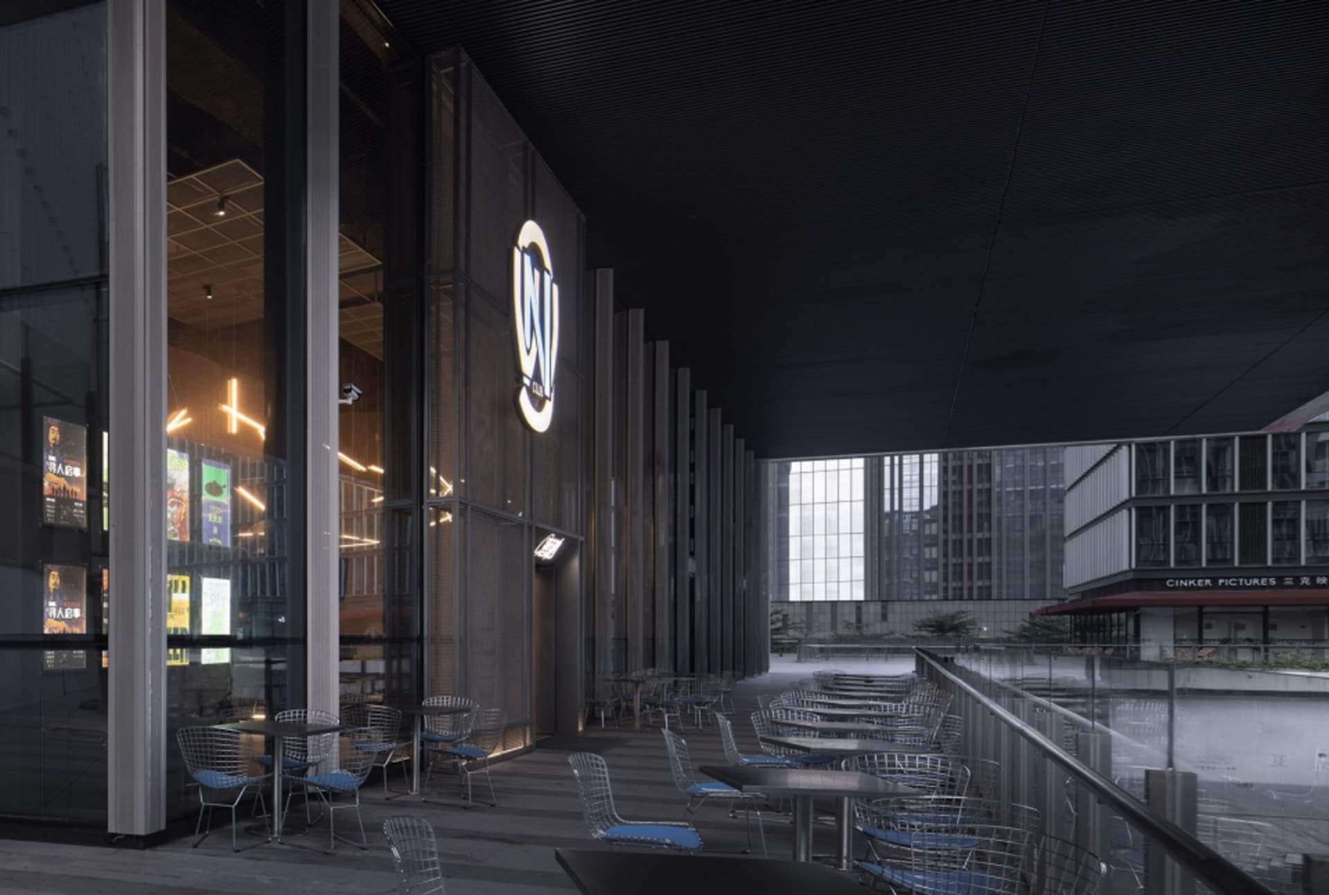 Modern restaurant exterior featuring metallic design, glass walls, and concrete base.