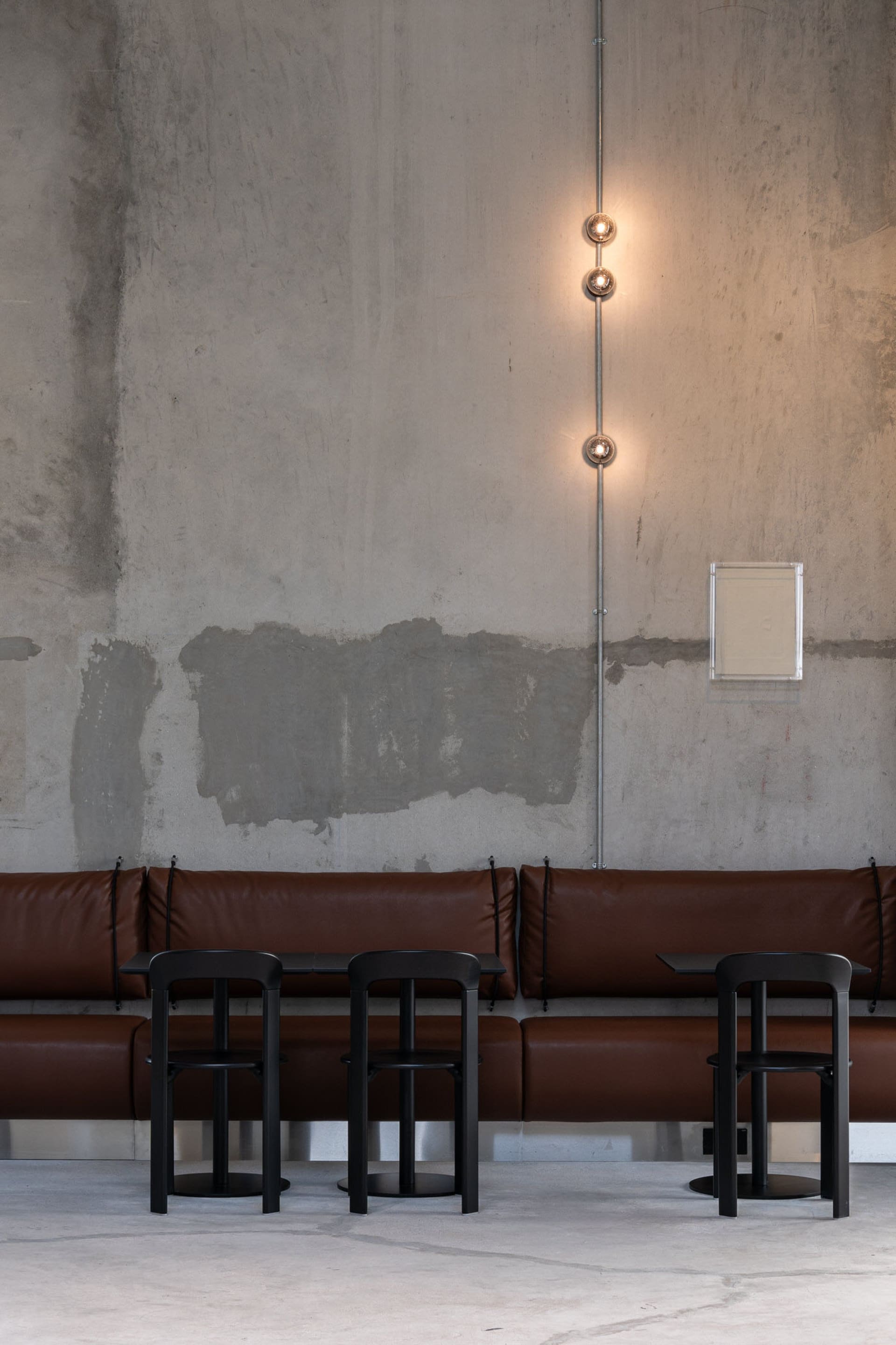 Industrial-style cafe interior with concrete walls and minimalist seating.