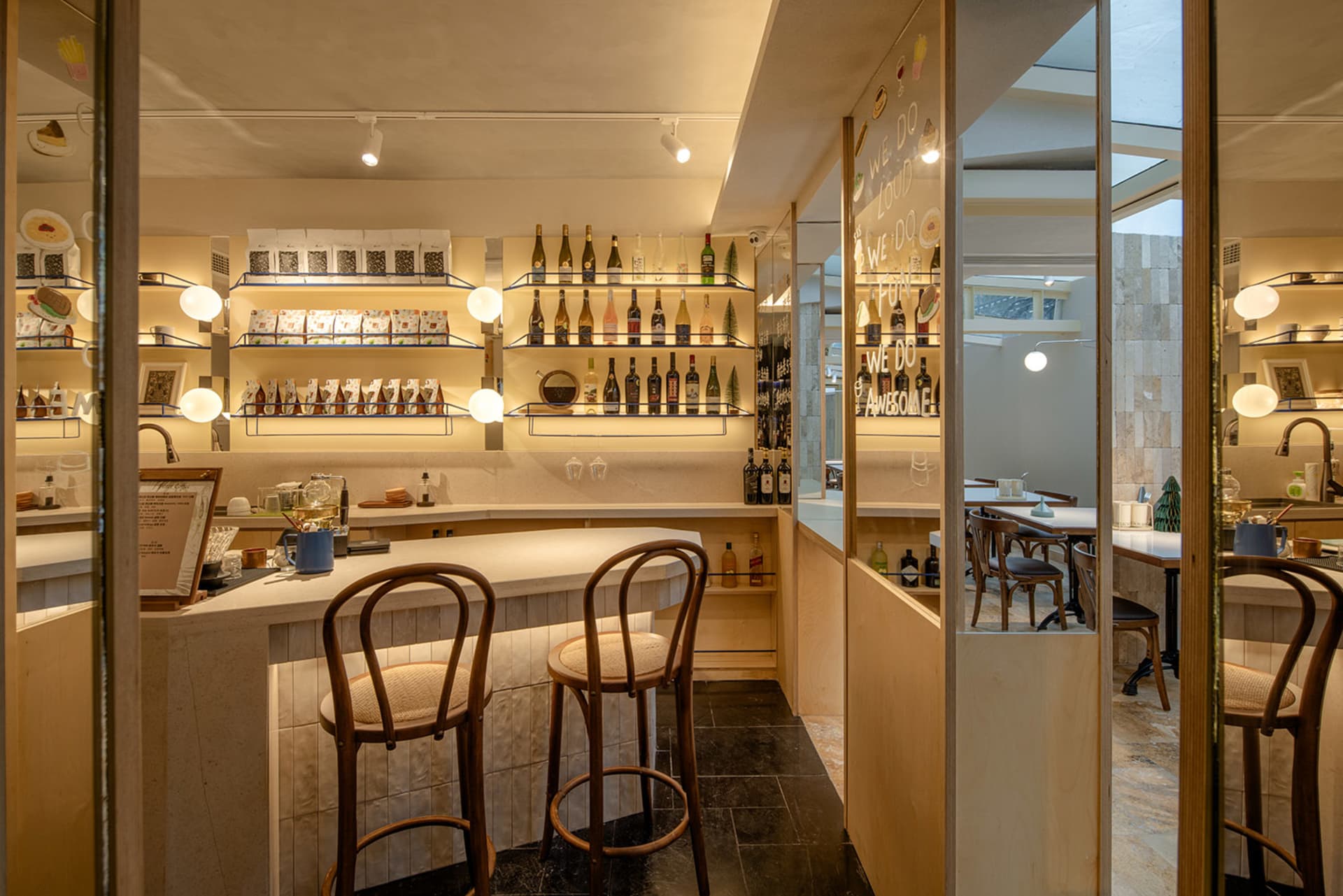 A modern bar interior with wooden stools, concrete walls, and bamboo accents.