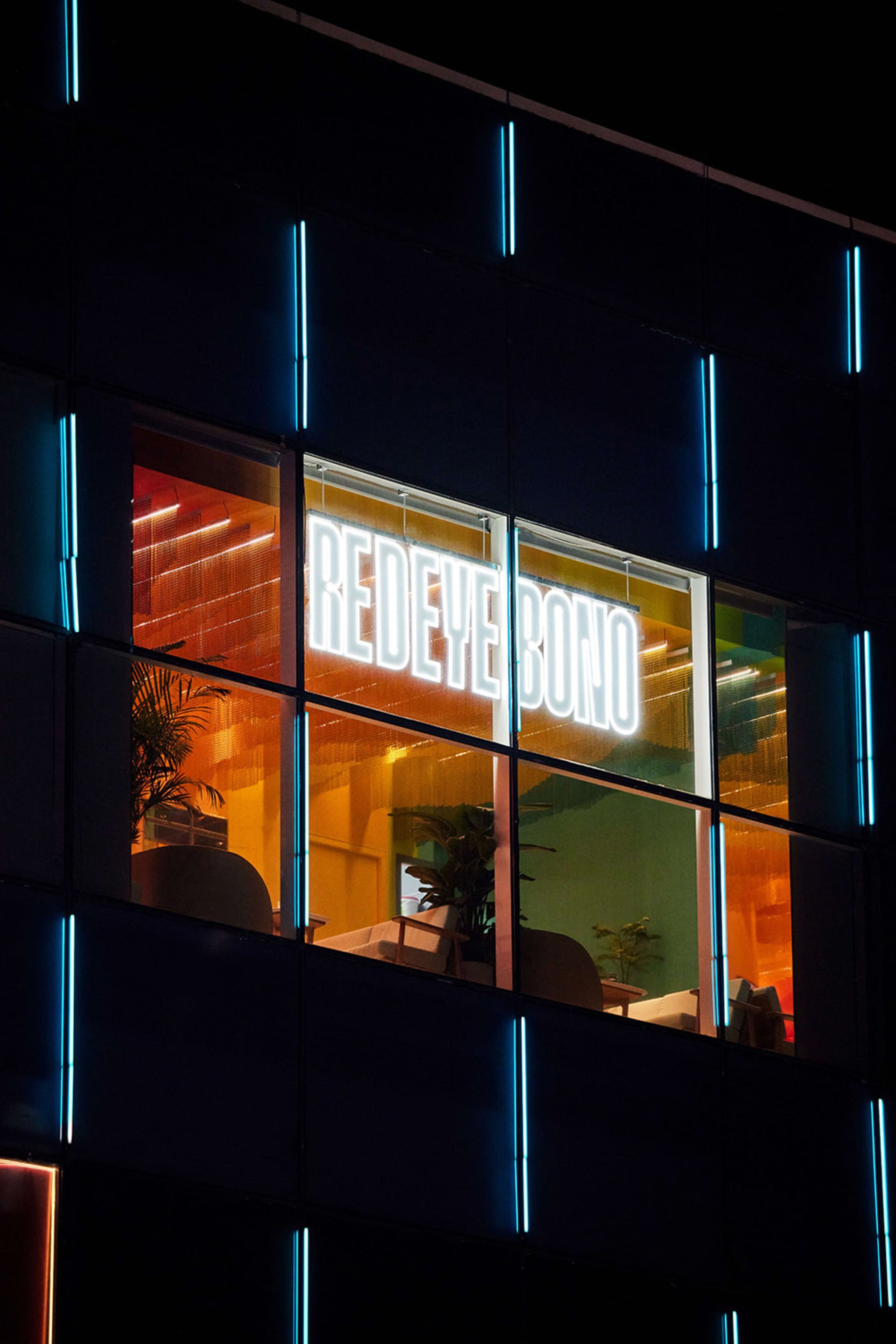 An office building with a modern glass exterior at night.