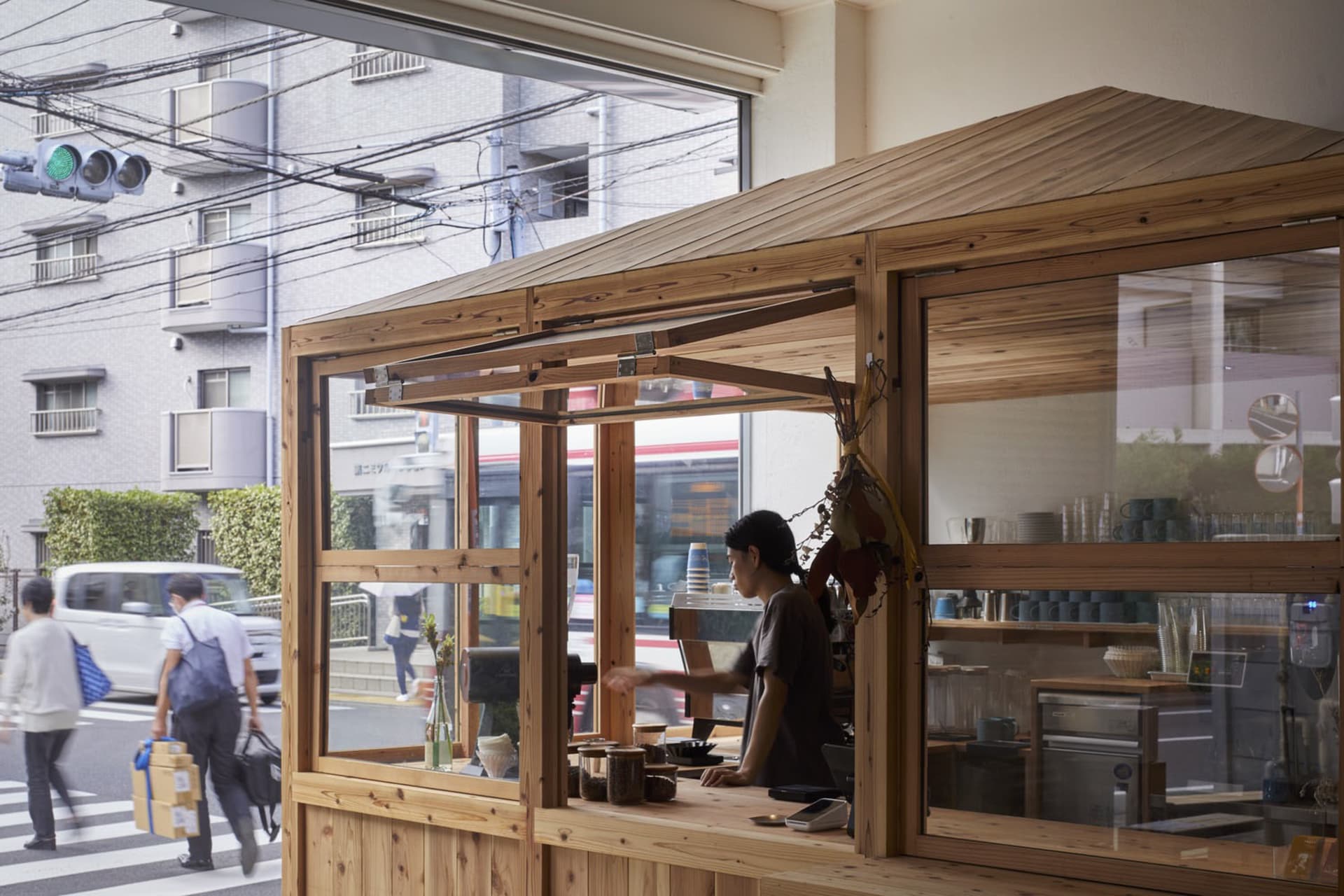 A modern wooden coffee shop with a glass front and an open interior.
