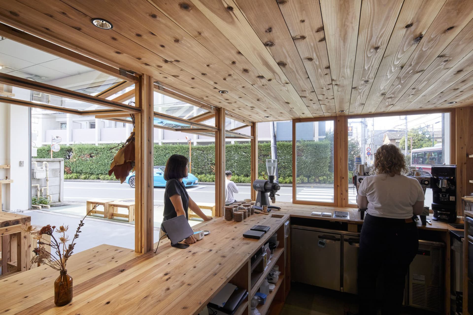 A modern coffee shop with a wooden counter, featuring a minimalist design with natural light and a comfortable atmosphere.