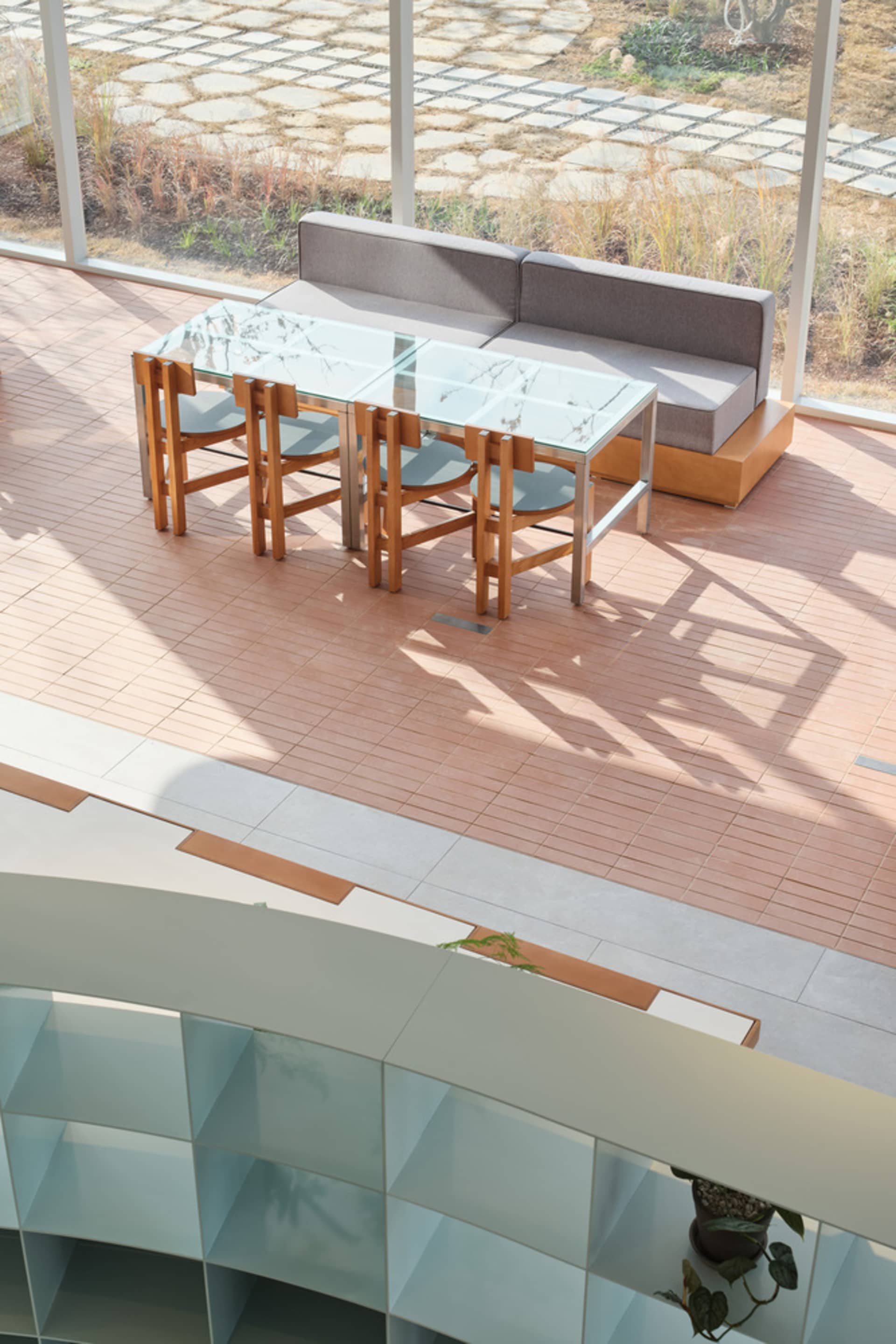 Modern lounge area featuring glass and wood furniture.