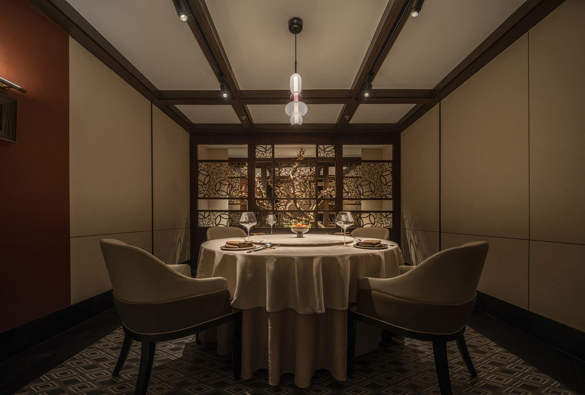 現代餐廳室內,圓形餐桌已擺設餐具,搭配木質餐椅與圓形燈具。
