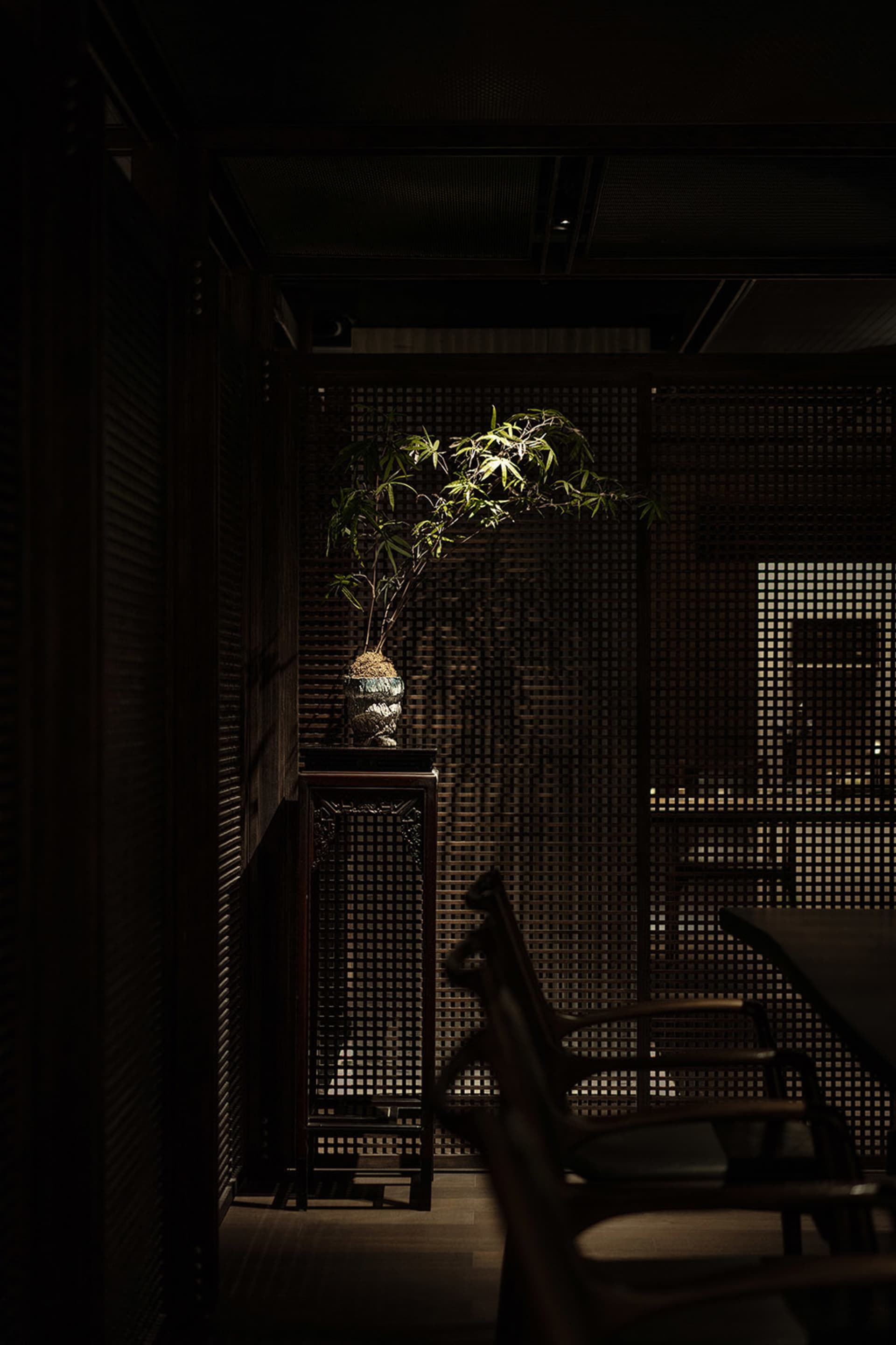 A traditional living room featuring wood-paneled walls, wooden furniture, and a potted plant.