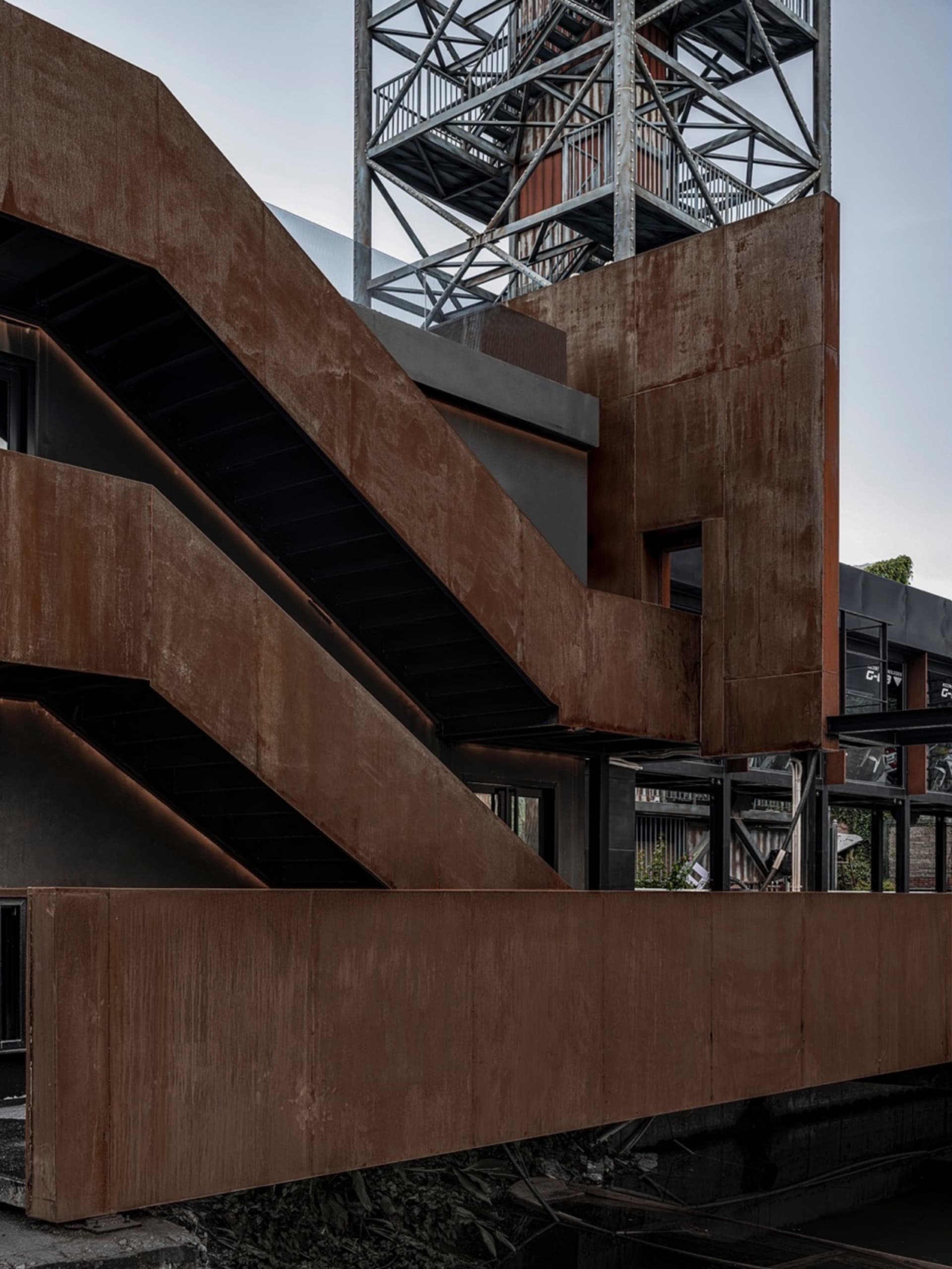 An industrial-style building exterior featuring corten steel materials.