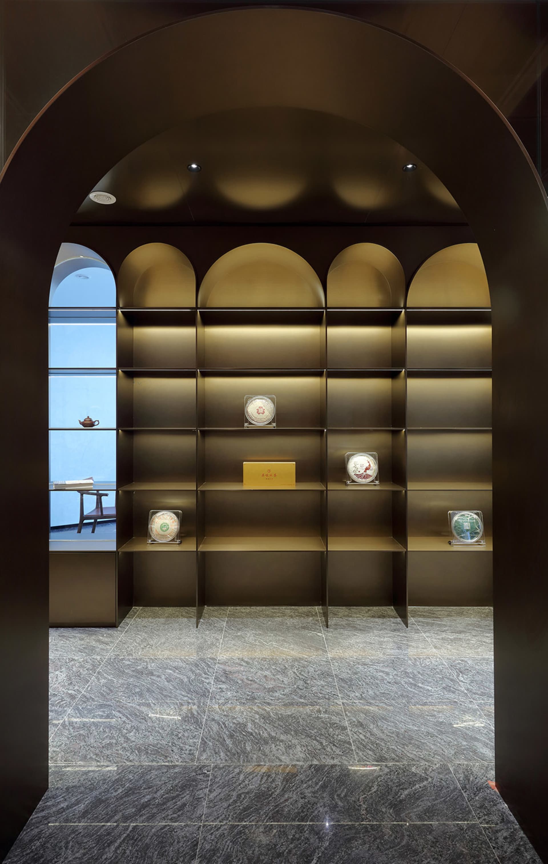 A modern interior with a metal bookshelf displaying various decorative items.
