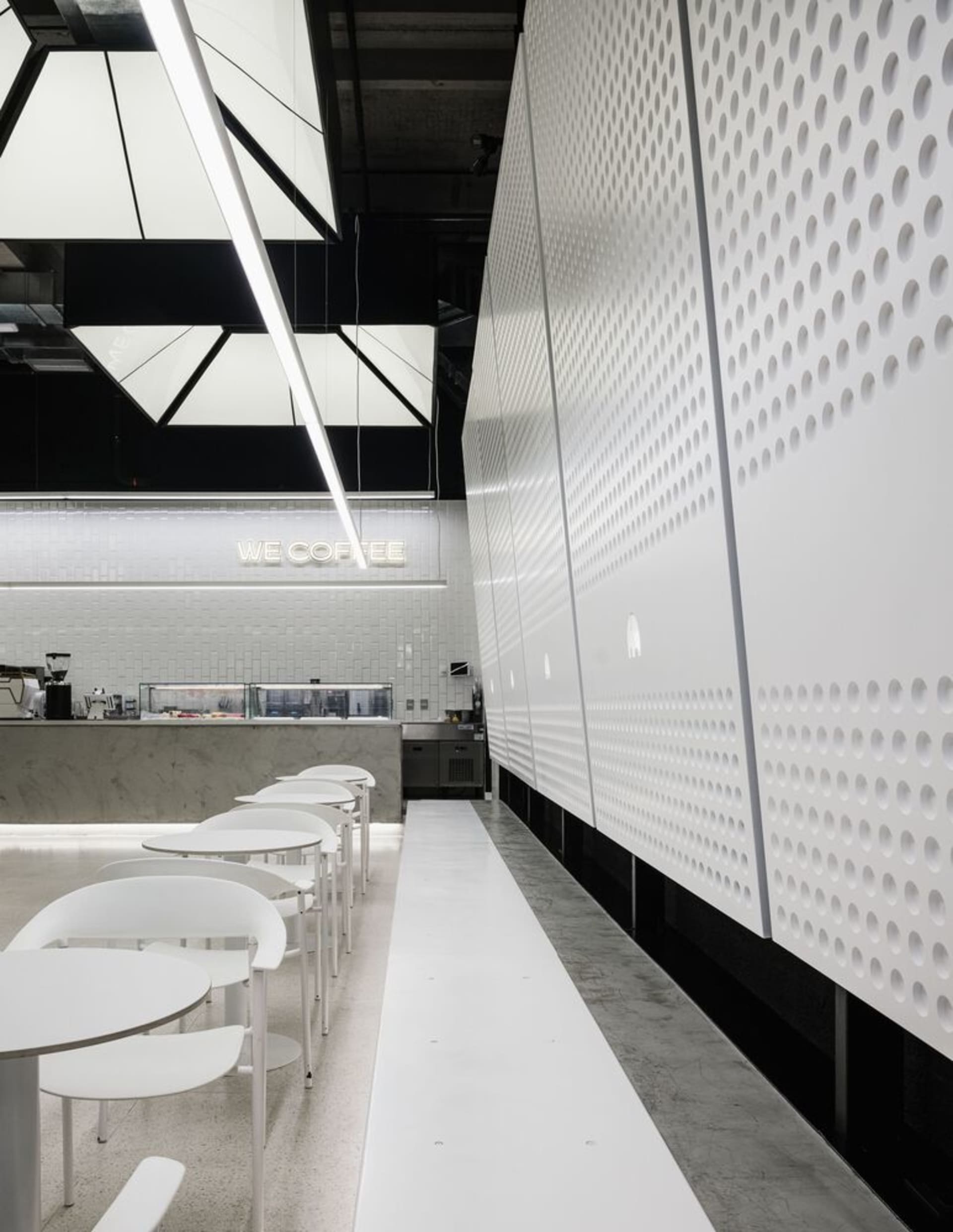 Modern coffee shop with minimalist design, white materials and bar counter.