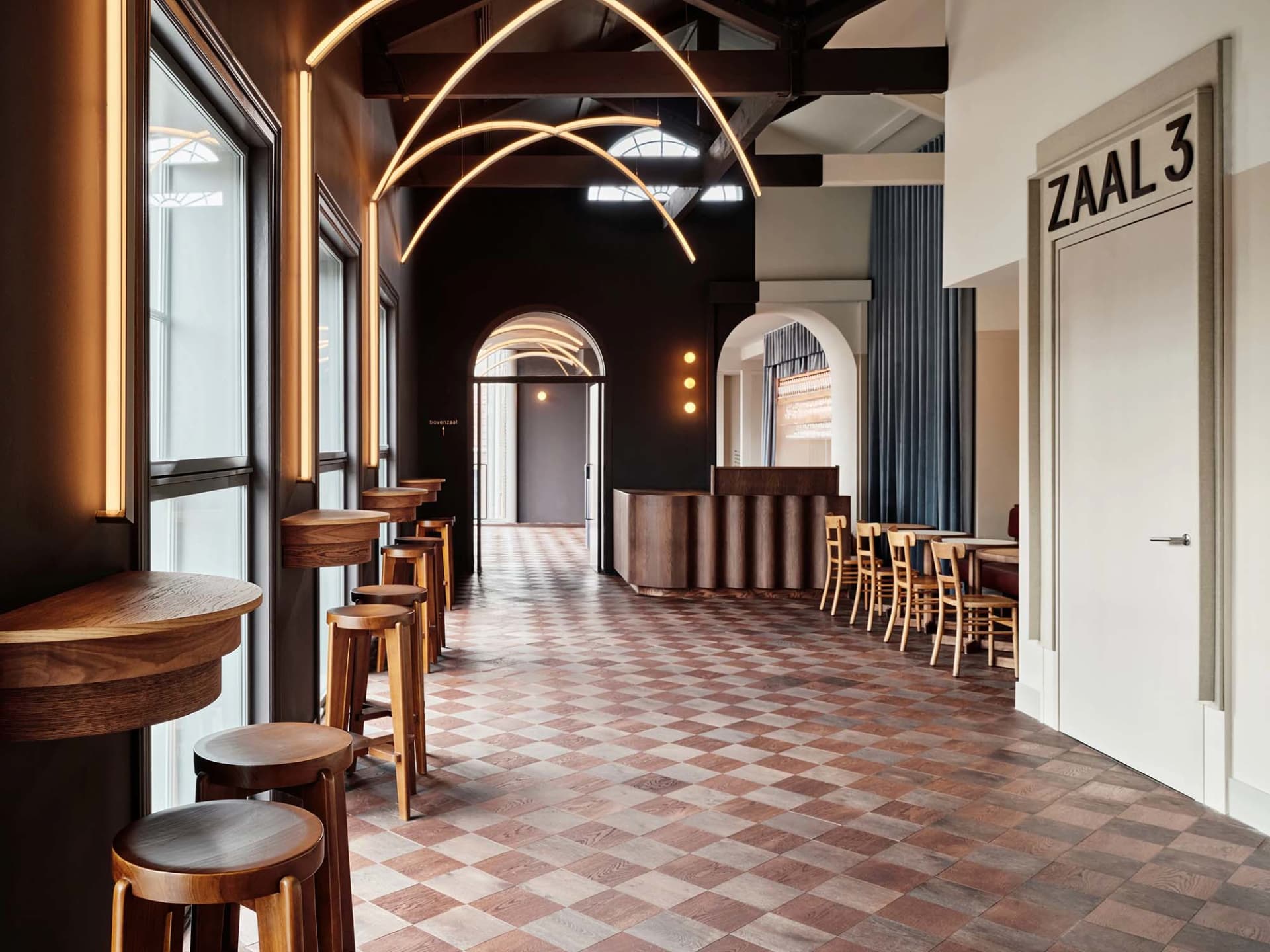 Interior of a cozy coffee shop featuring wooden stools and tables.
