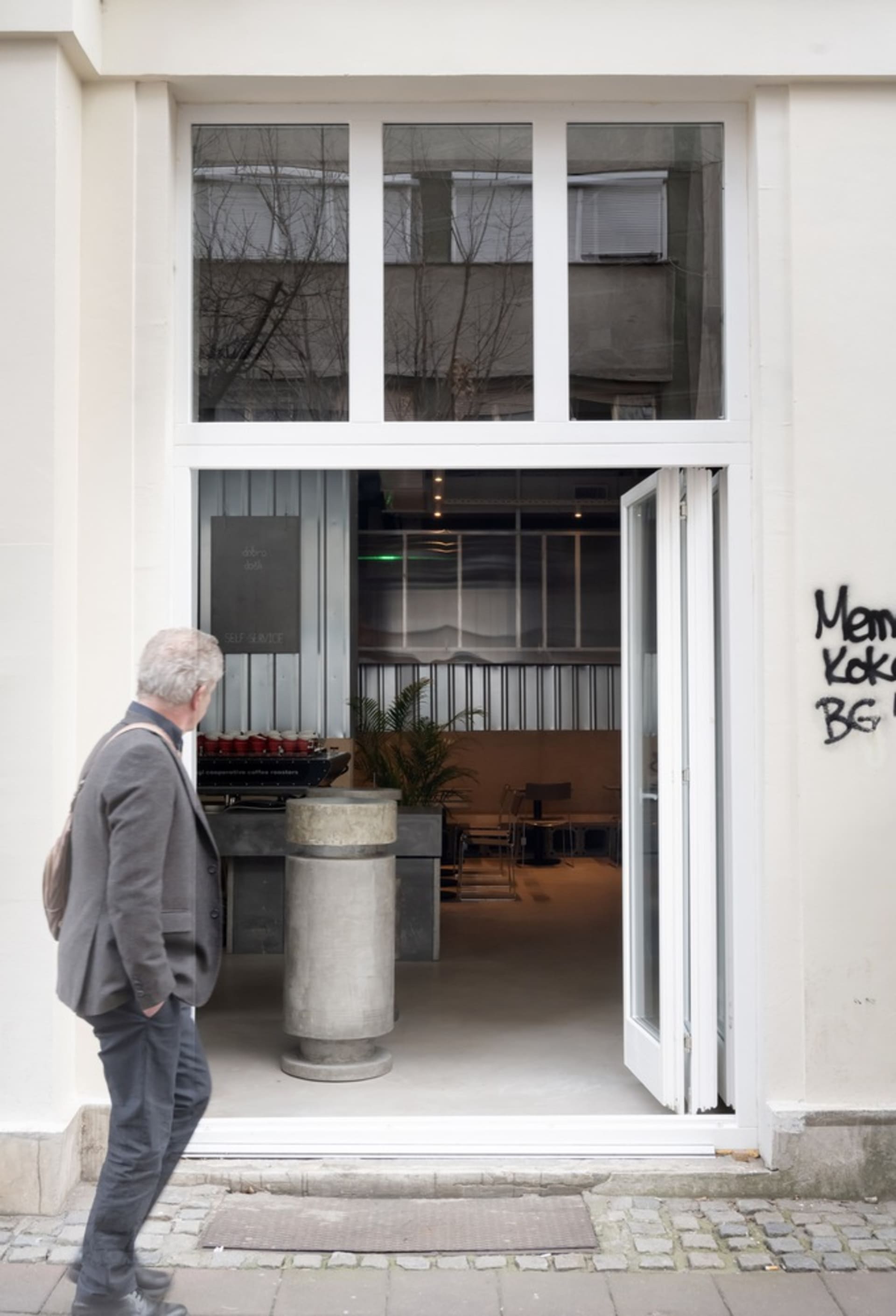 A minimalist design storefront with a concrete entrance and glass windows.