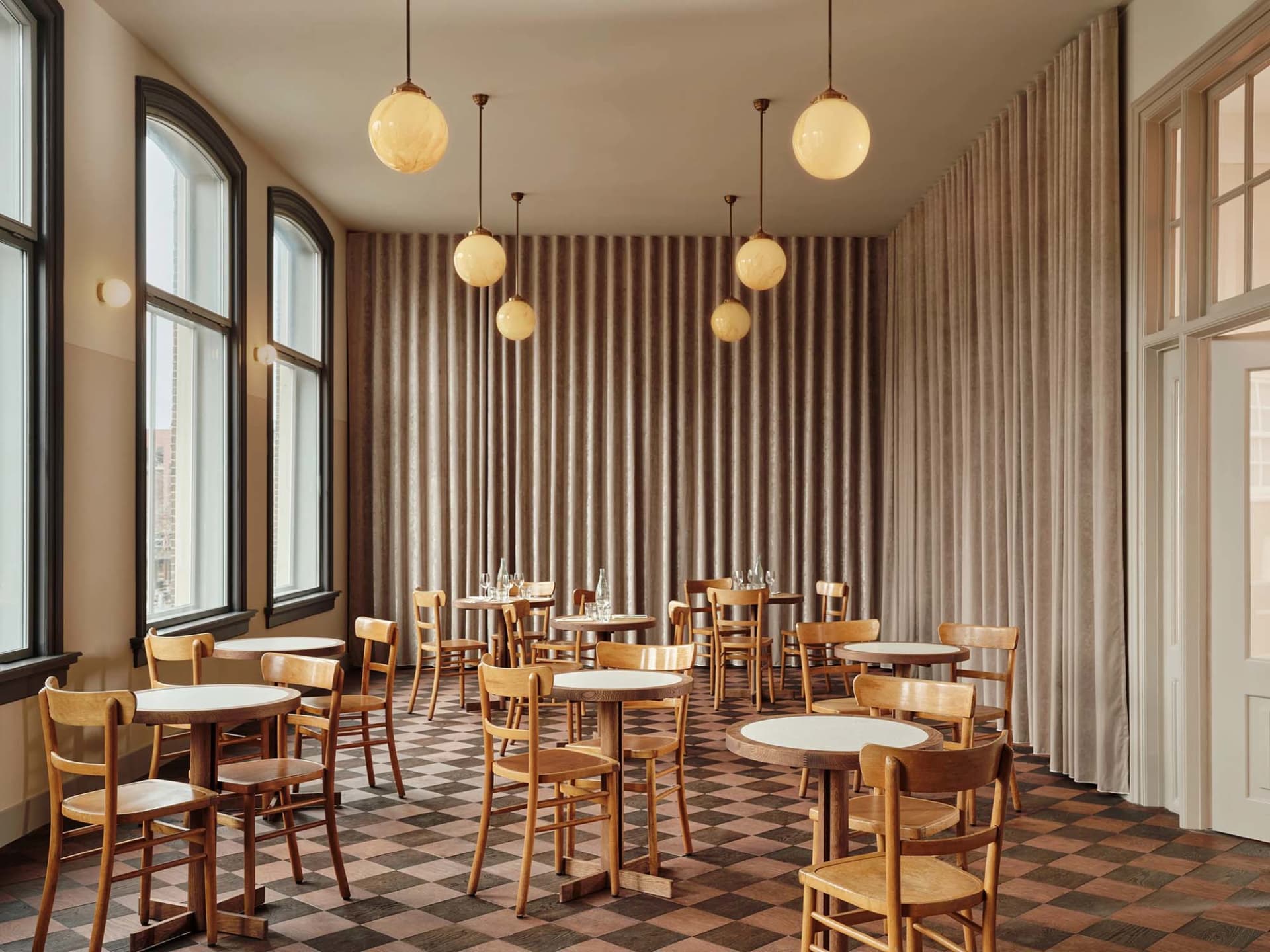 Dining room with modern wooden furniture and round tables.