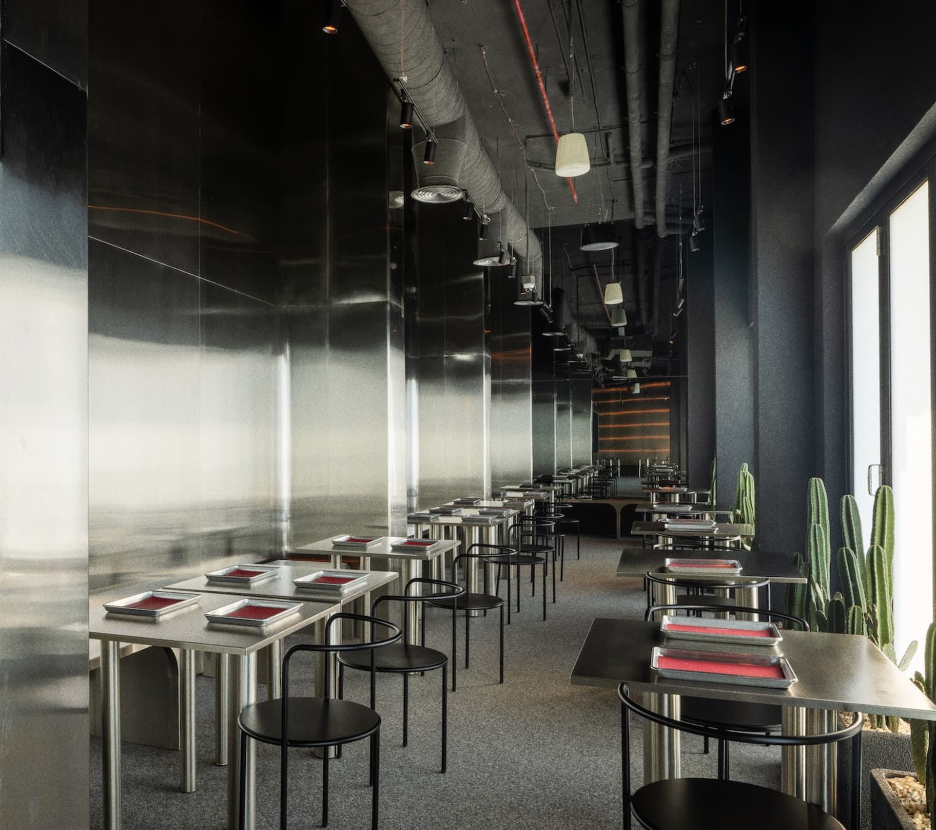 現代簡約餐廳室內,配有金屬吧台與座椅。