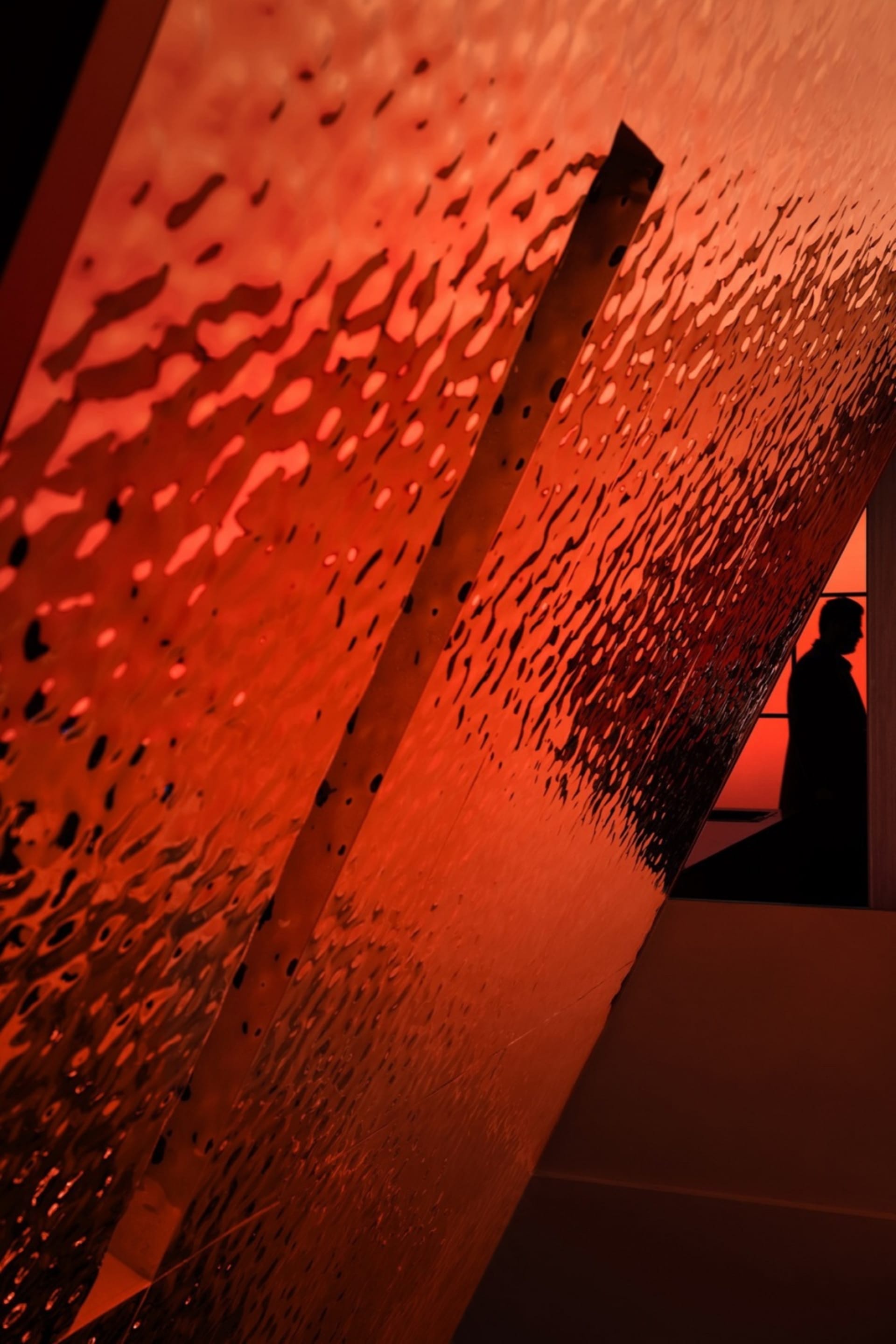 Red glass panels reflecting light in an interior space.