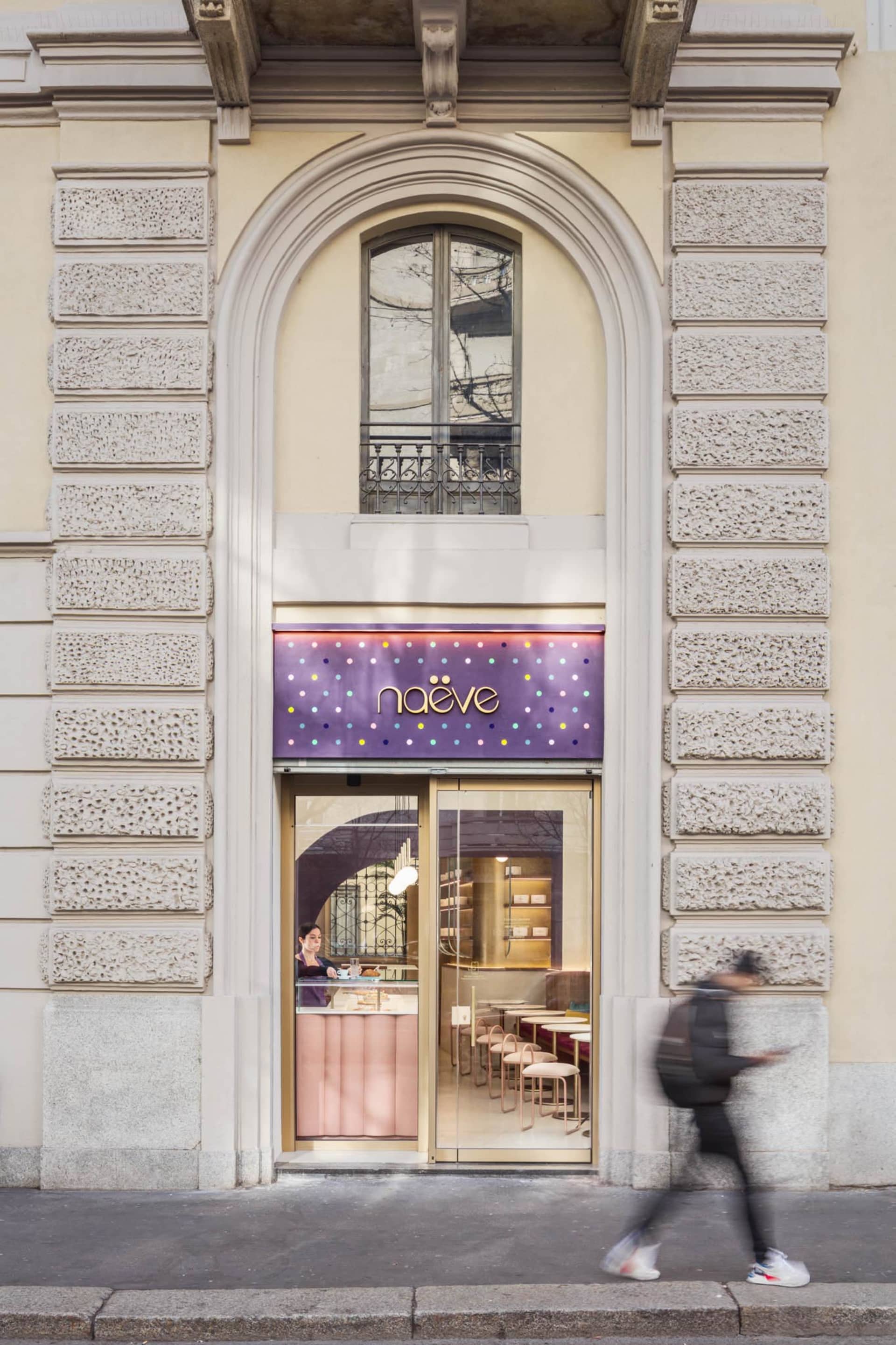 A modern cafe storefront with glass and concrete materials, featuring the word "naeve"