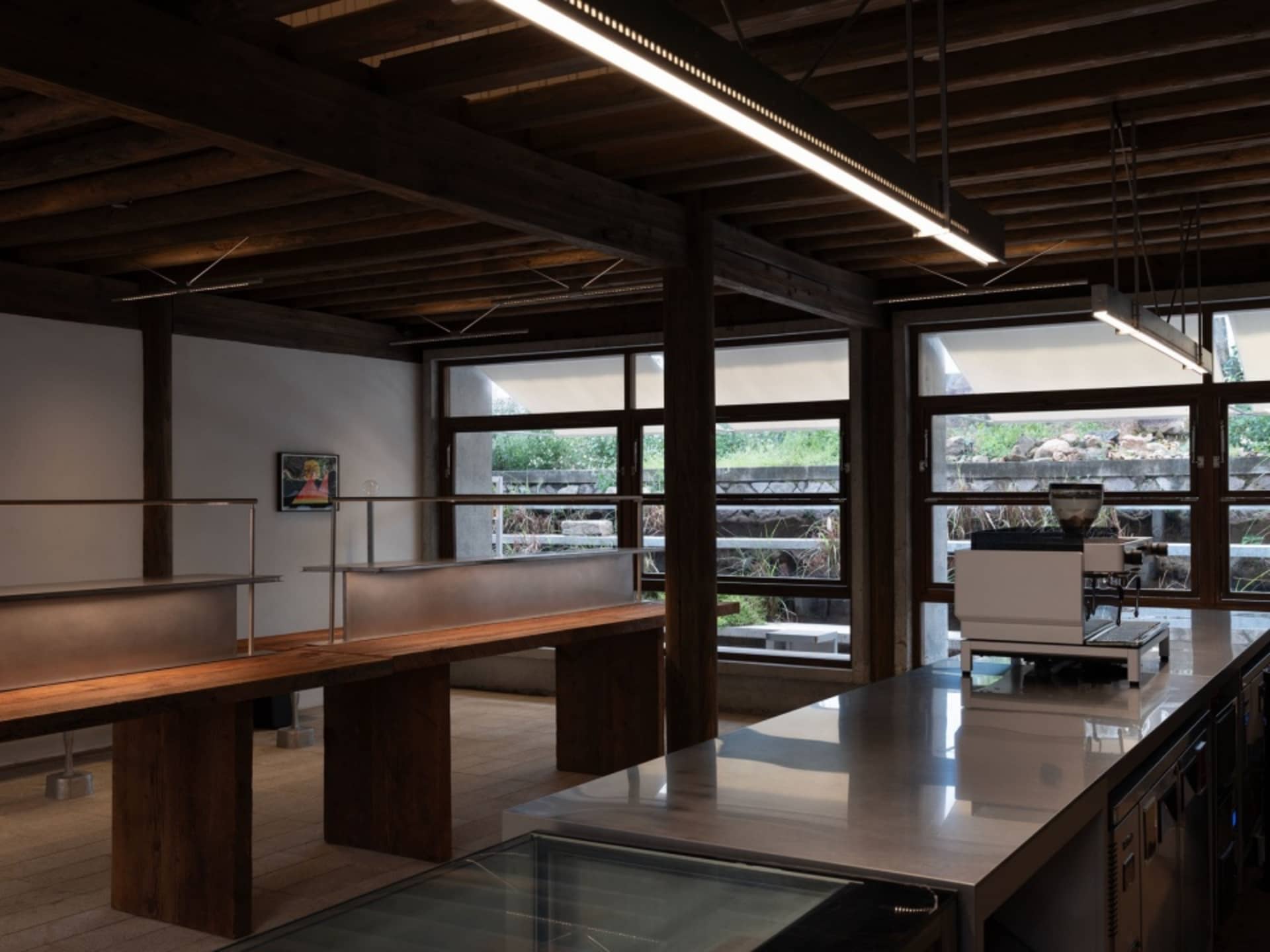 Modern restaurant interior with metal tables and glass walls
