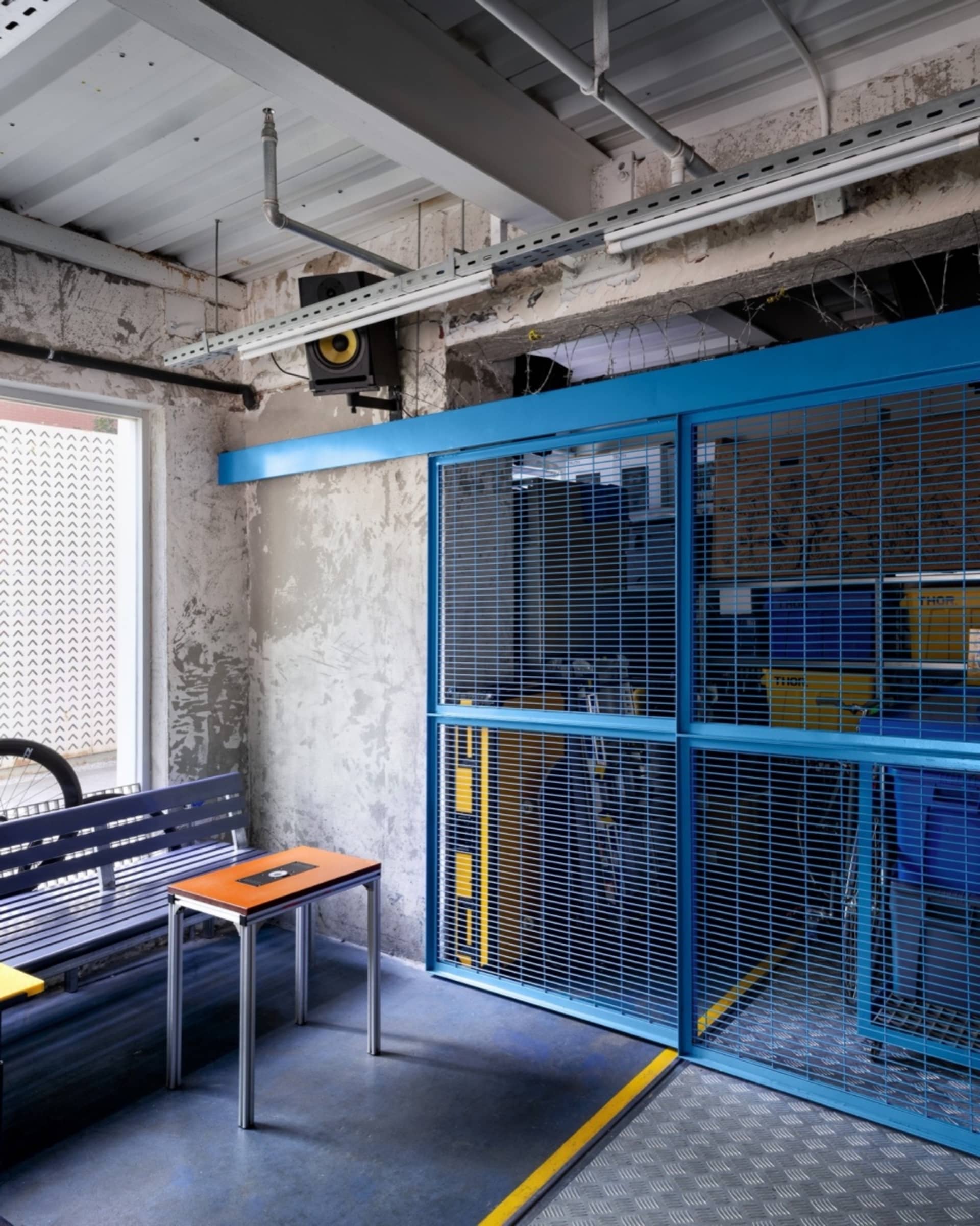 An industrial warehouse interior with a metal gate and concrete walls.