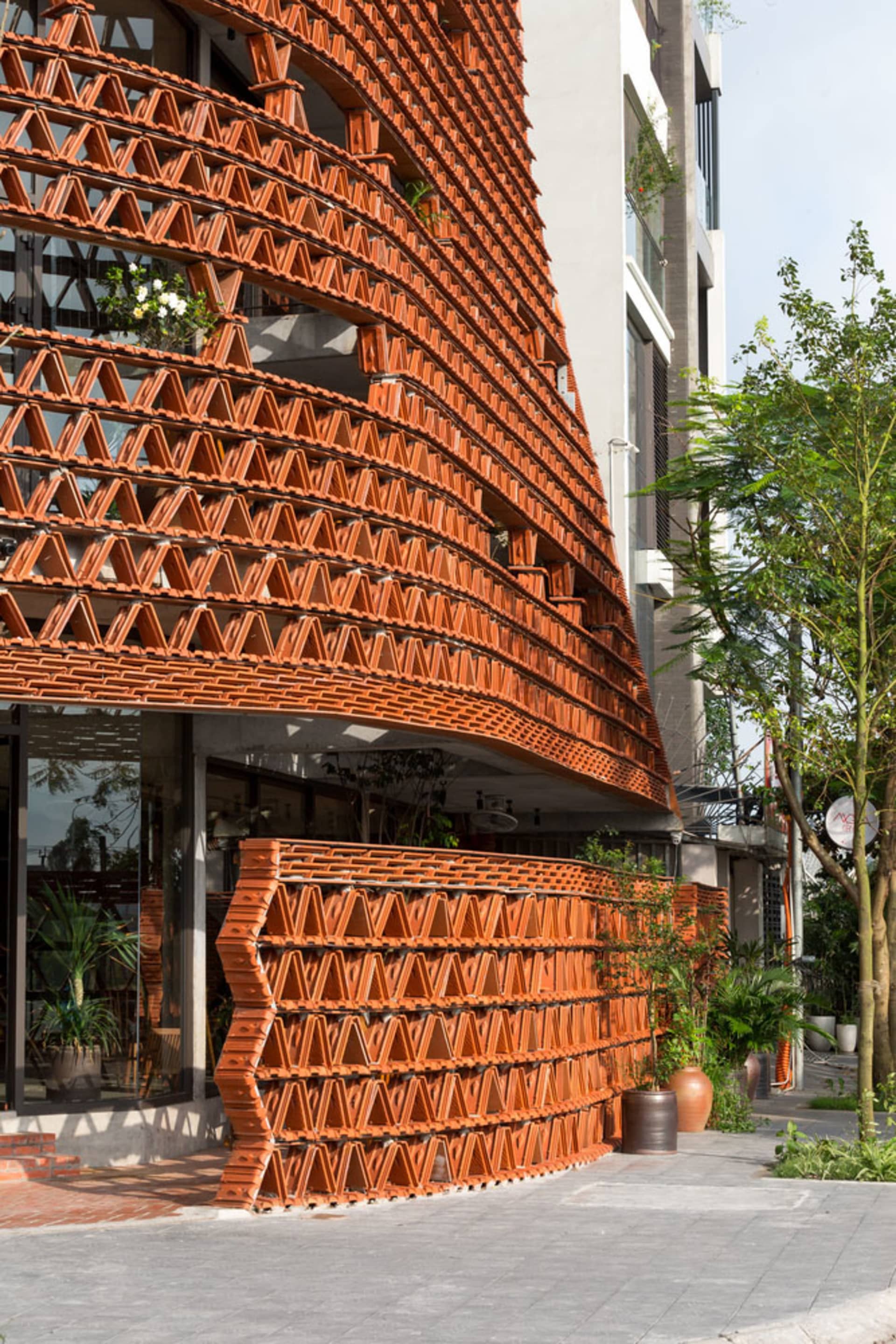 Modern building with curved brick facade in an urban retail area.