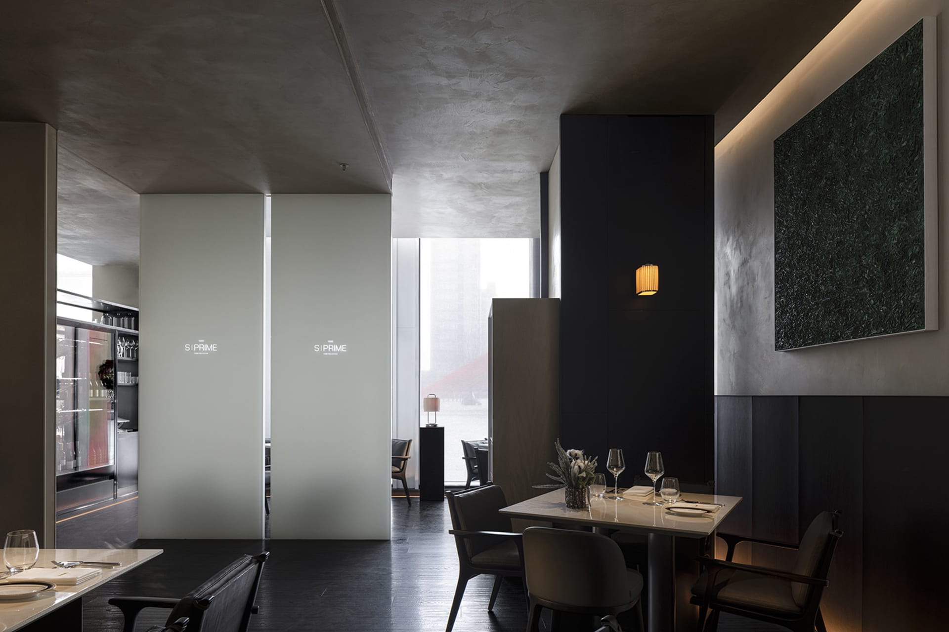 Modern restaurant interior with concrete walls, black marble accents, and minimalist design elements.