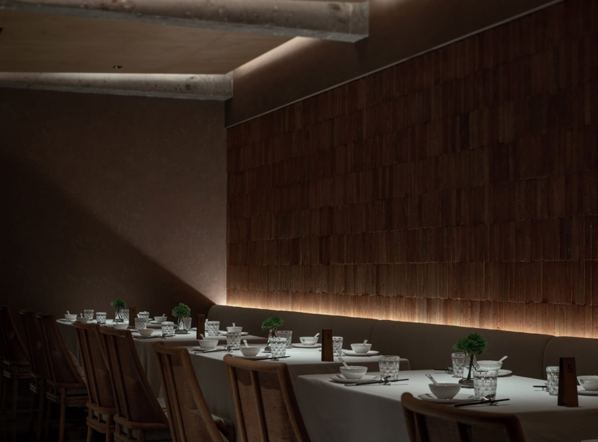 Dining area in a modern restaurant with wooden walls and white tablecloths