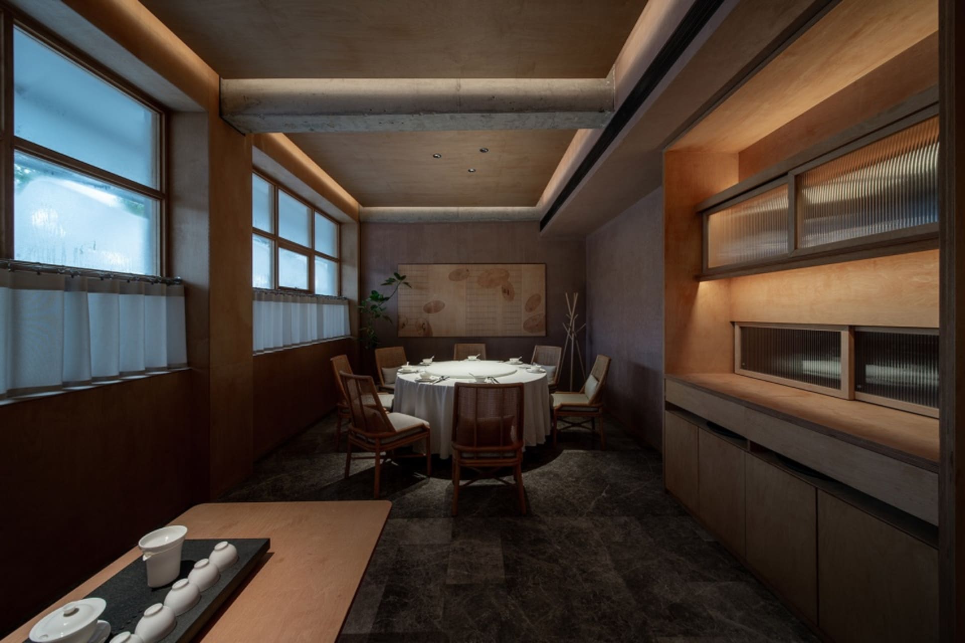 A modern restaurant interior featuring dark wooden elements and stone flooring.