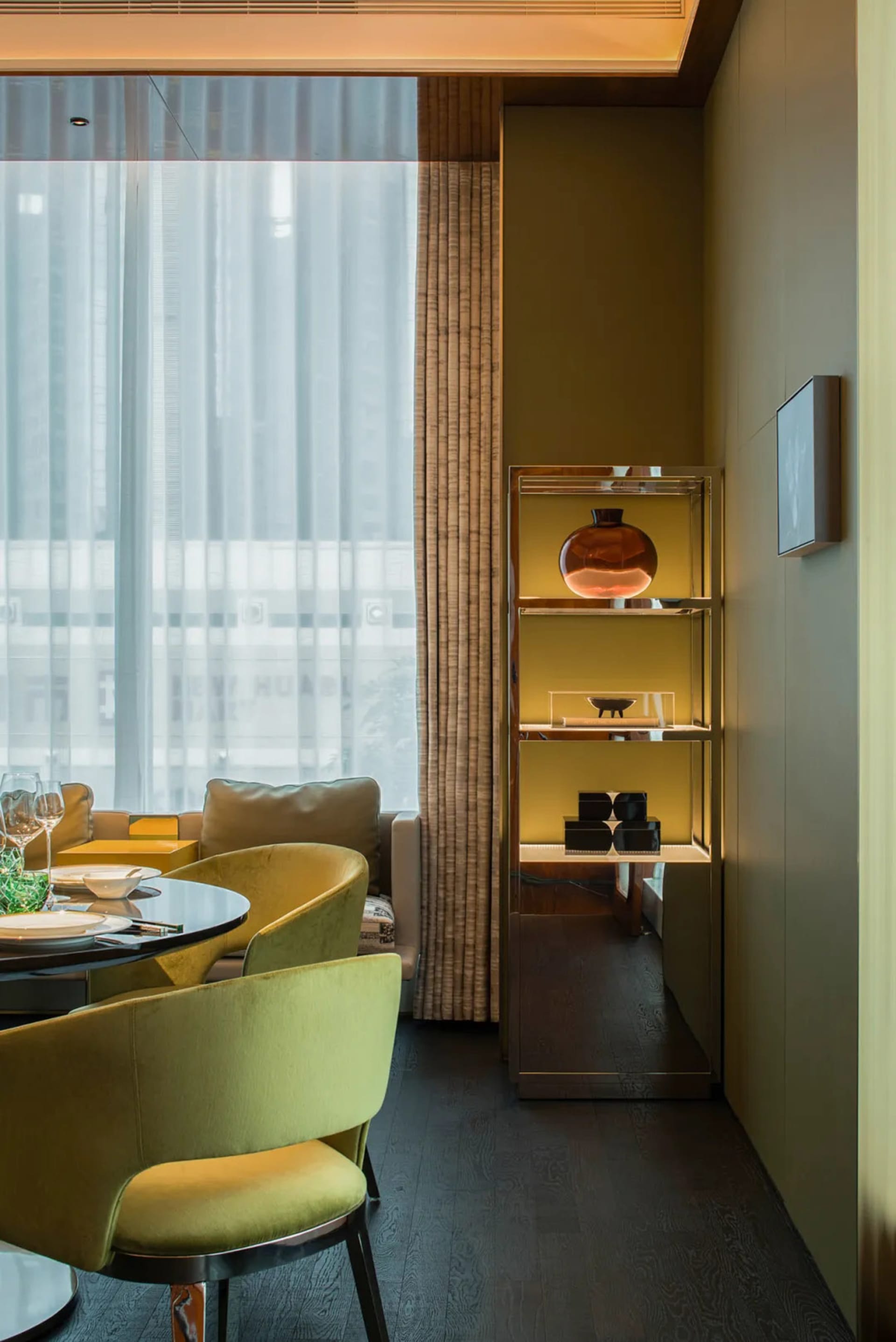 Modern dining room featuring a yellow storage unit with various decorative items.