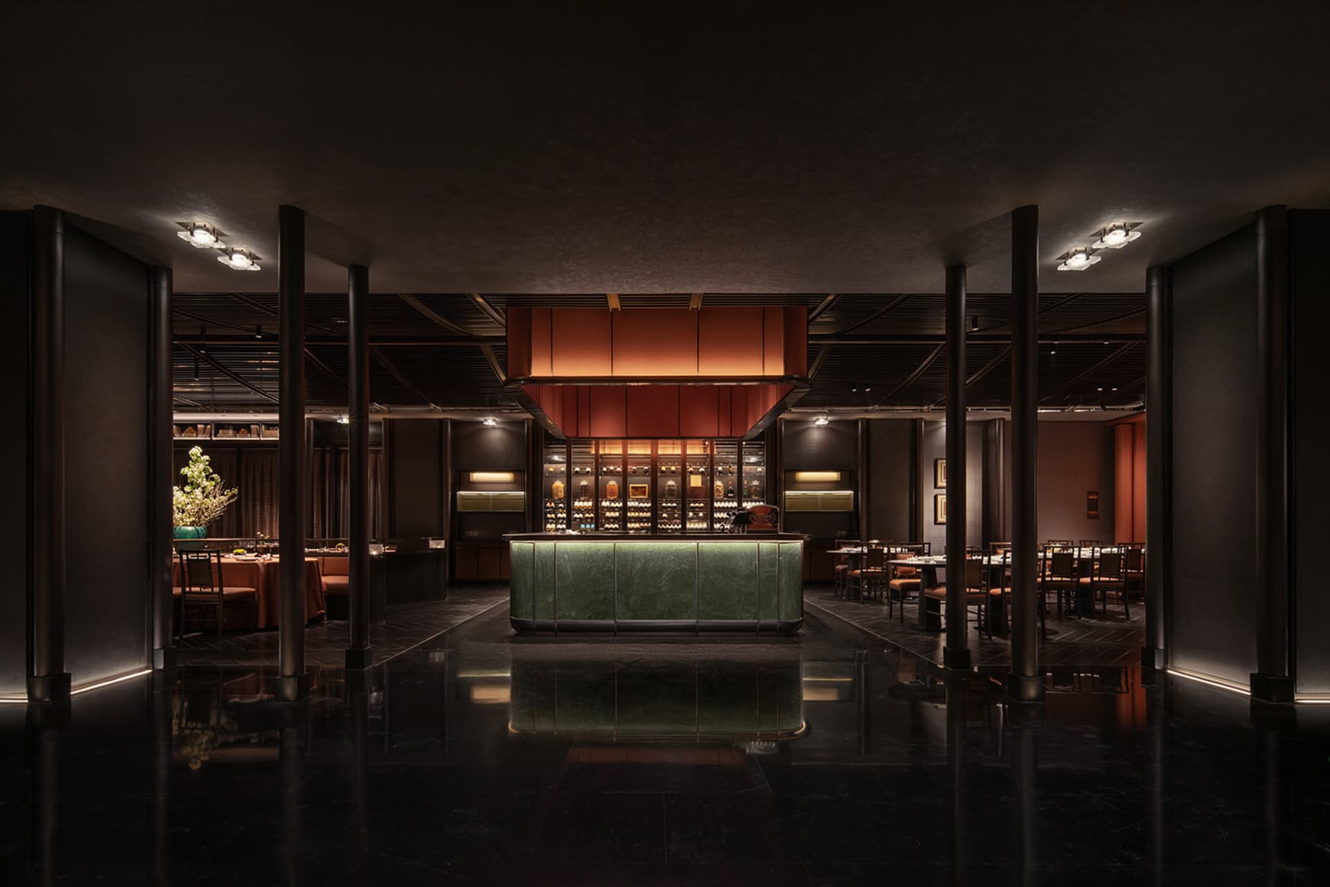 Interior of a minimalist restaurant with a marble bar, wooden tables, and metal chairs.