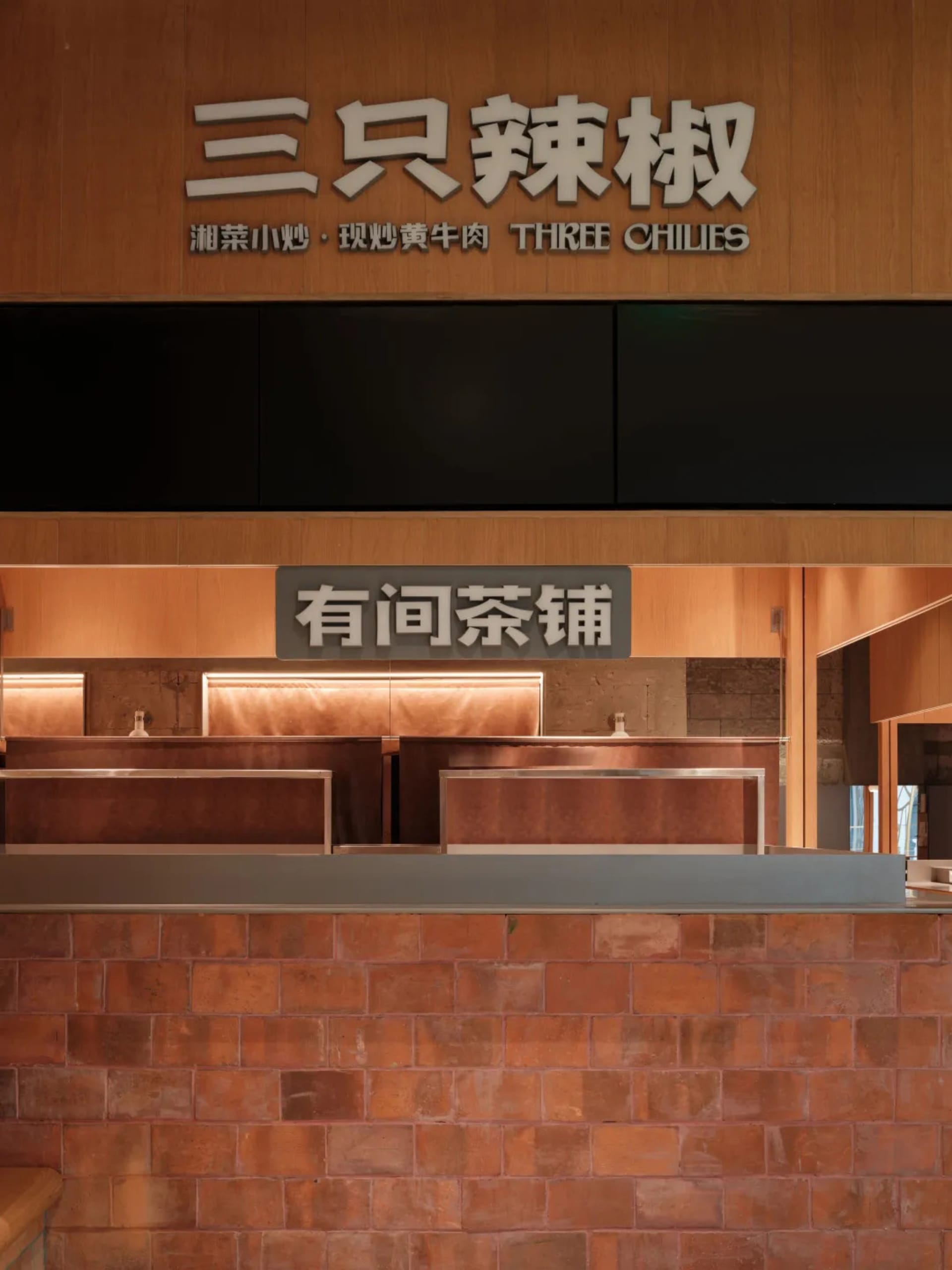 現代餐廳室內，展現木質牆板與金屬吧台。