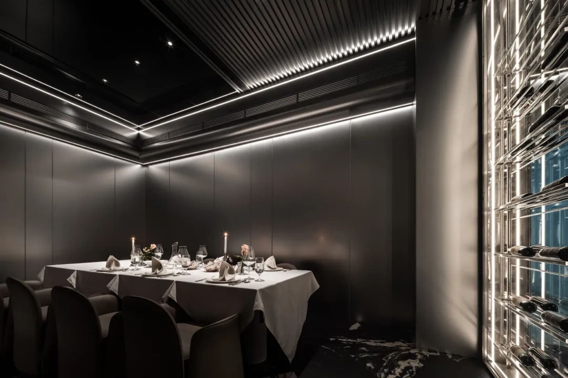 一間時尚現代的餐廳餐廳,擁有金屬質感牆面,搭配柔和LED燈光照明,並設有餐桌