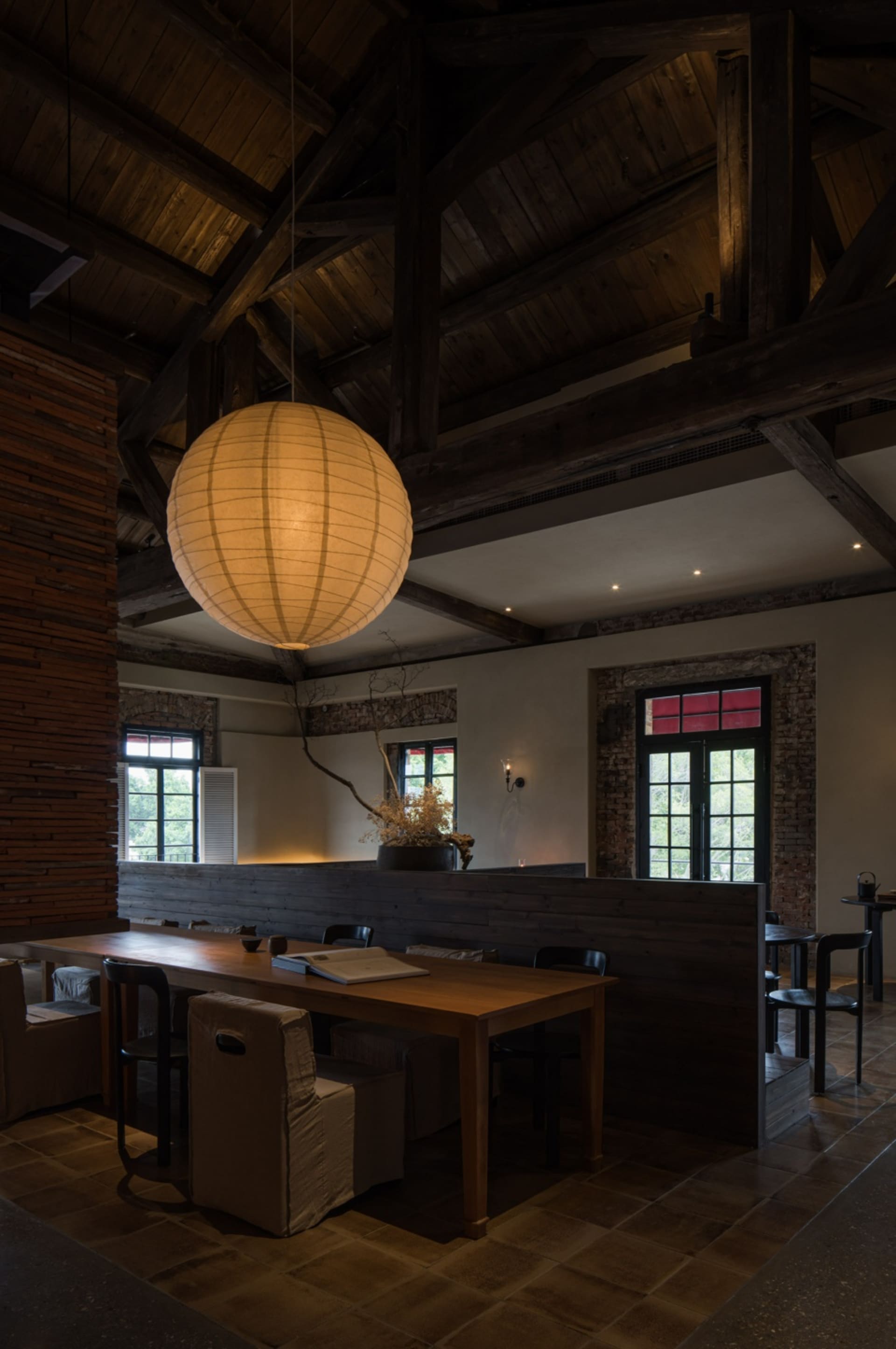 An industrial-style restaurant interior with a wooden table setting.