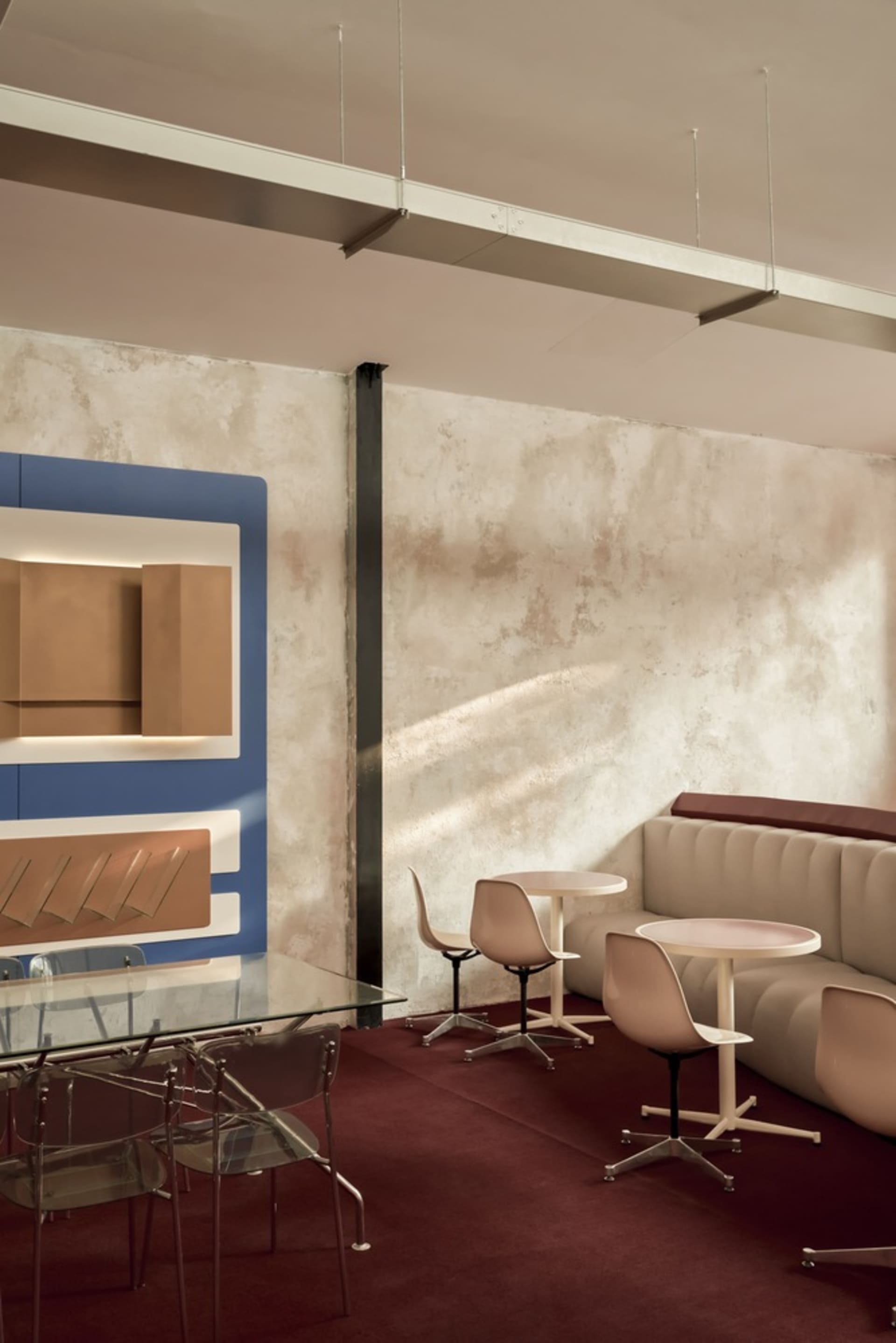 A modern cafe interior featuring concrete walls and metal seating.