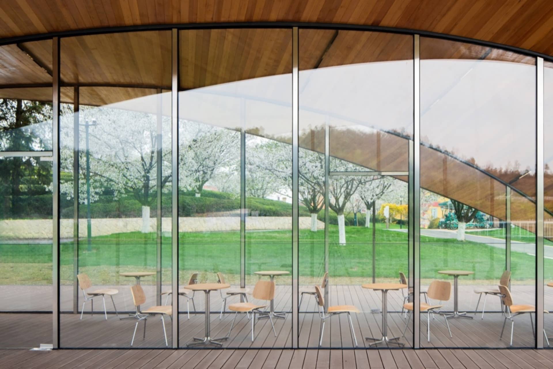 View of outdoor seating area through large glass windows.