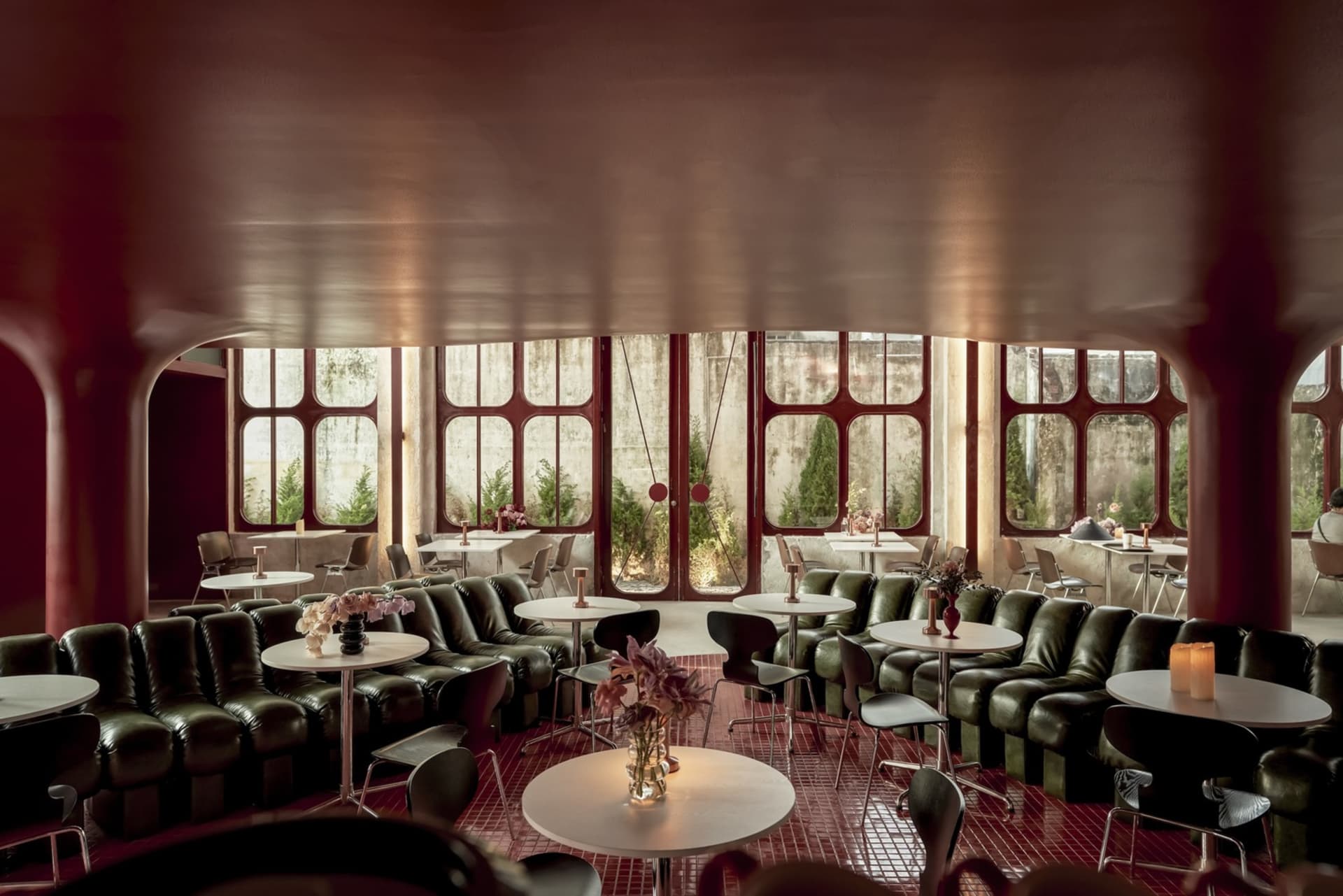 An industrial-themed restaurant interior with metal seating and tables.
