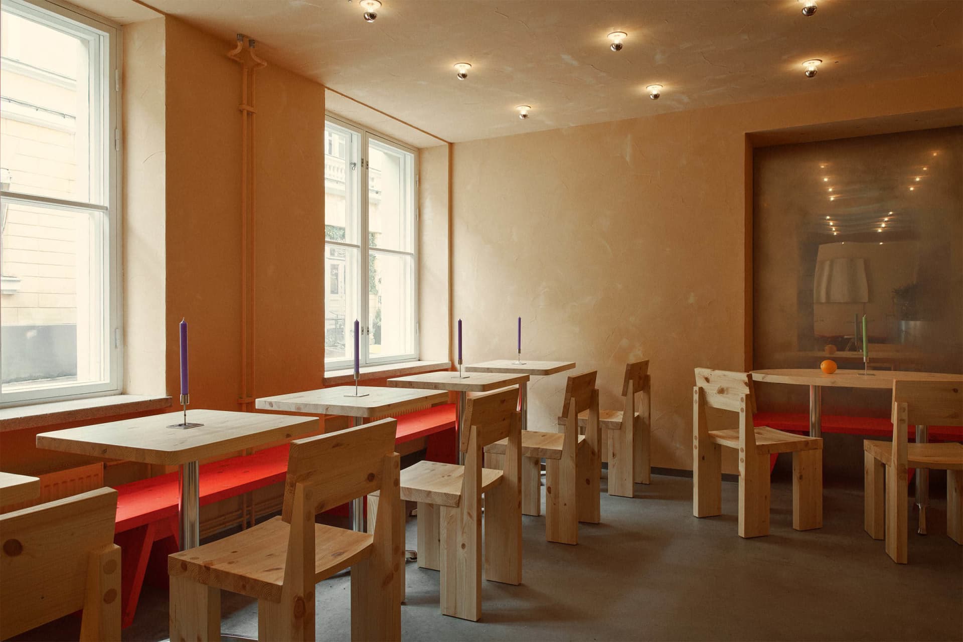 Restaurant with industrial-style wooden furniture and red benches
