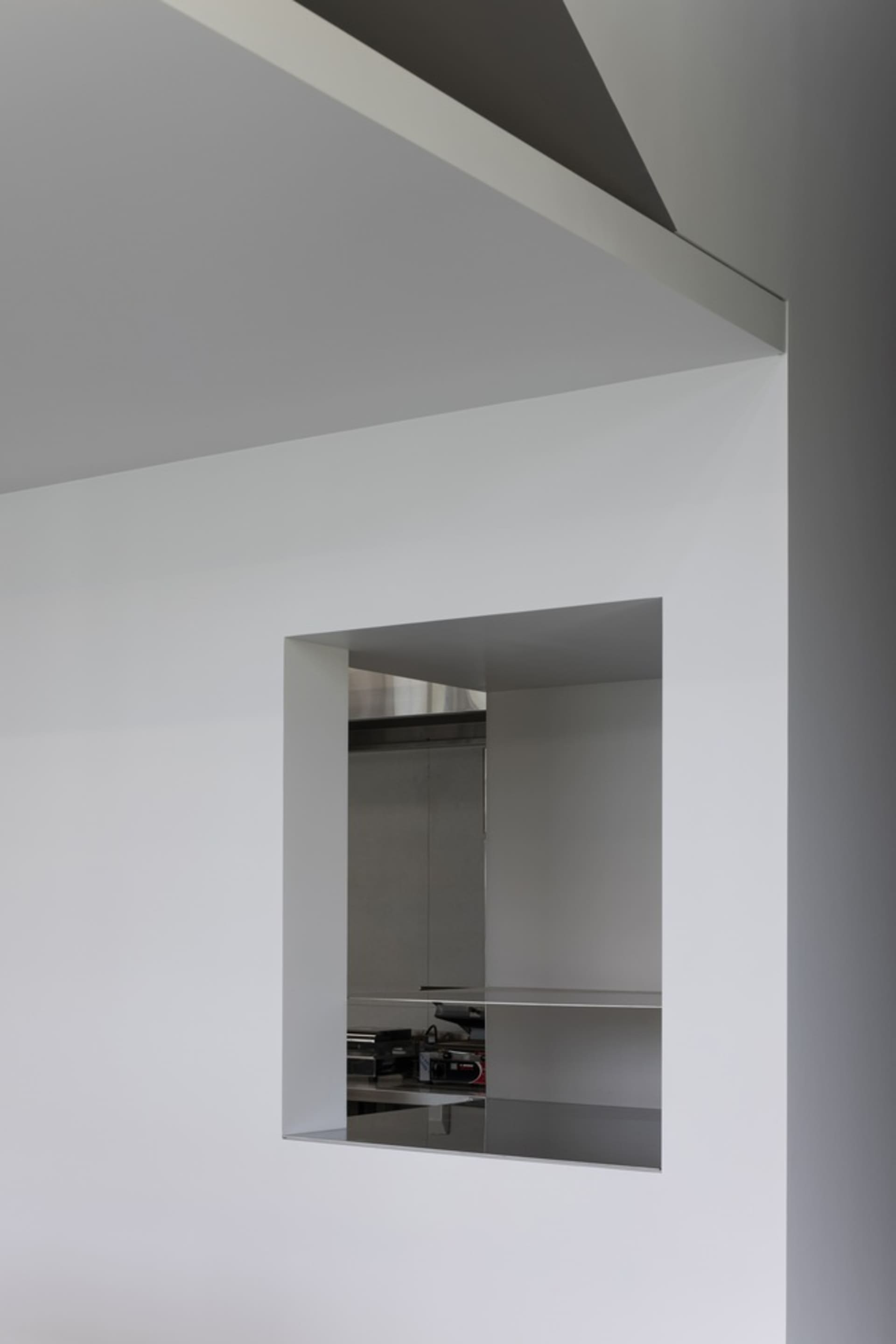A modern kitchen interior with metallic wall panels and stainless steel countertops.