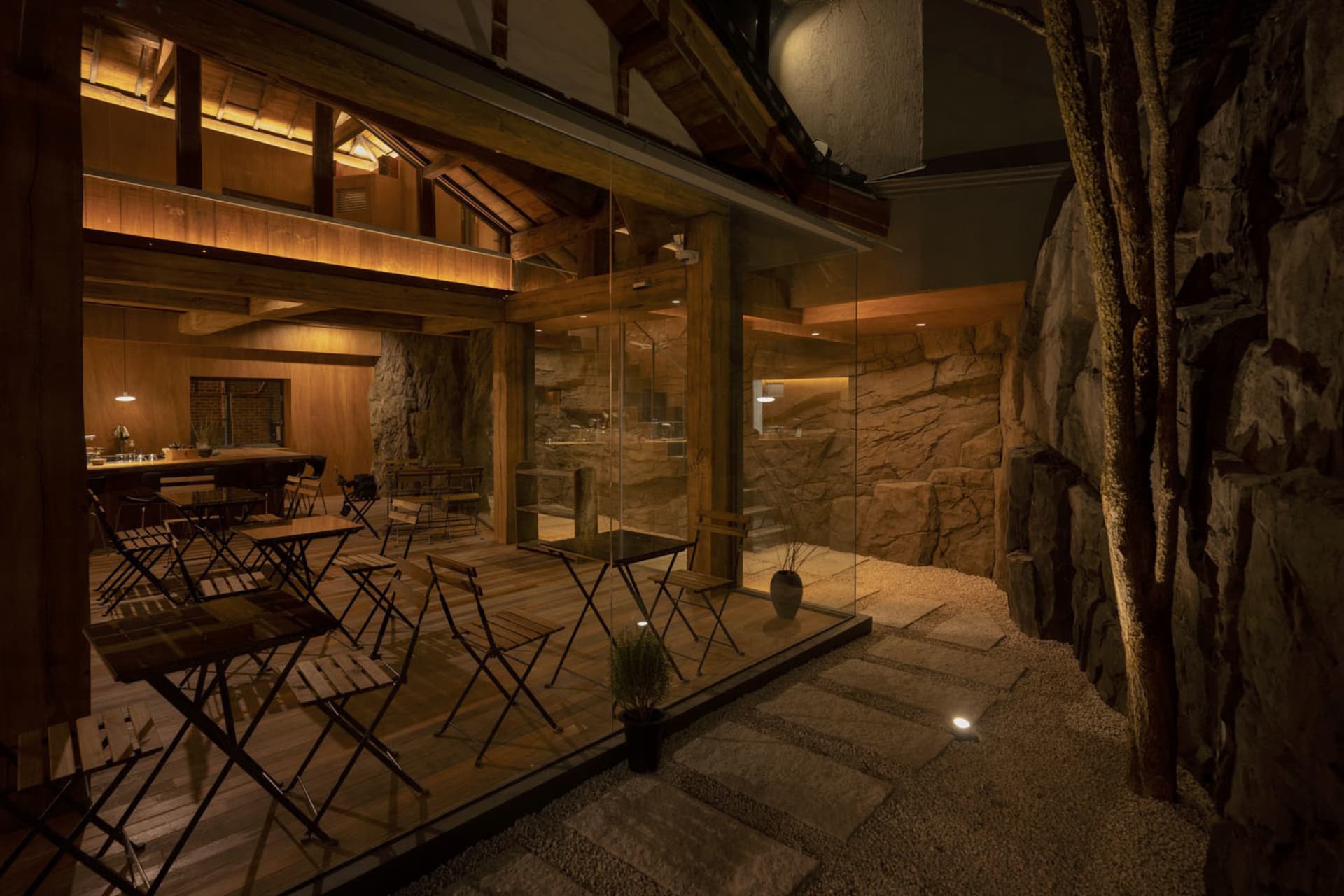 A wooden rock-themed restaurant bathroom with exposed wooden beams and walls covered in rock textures