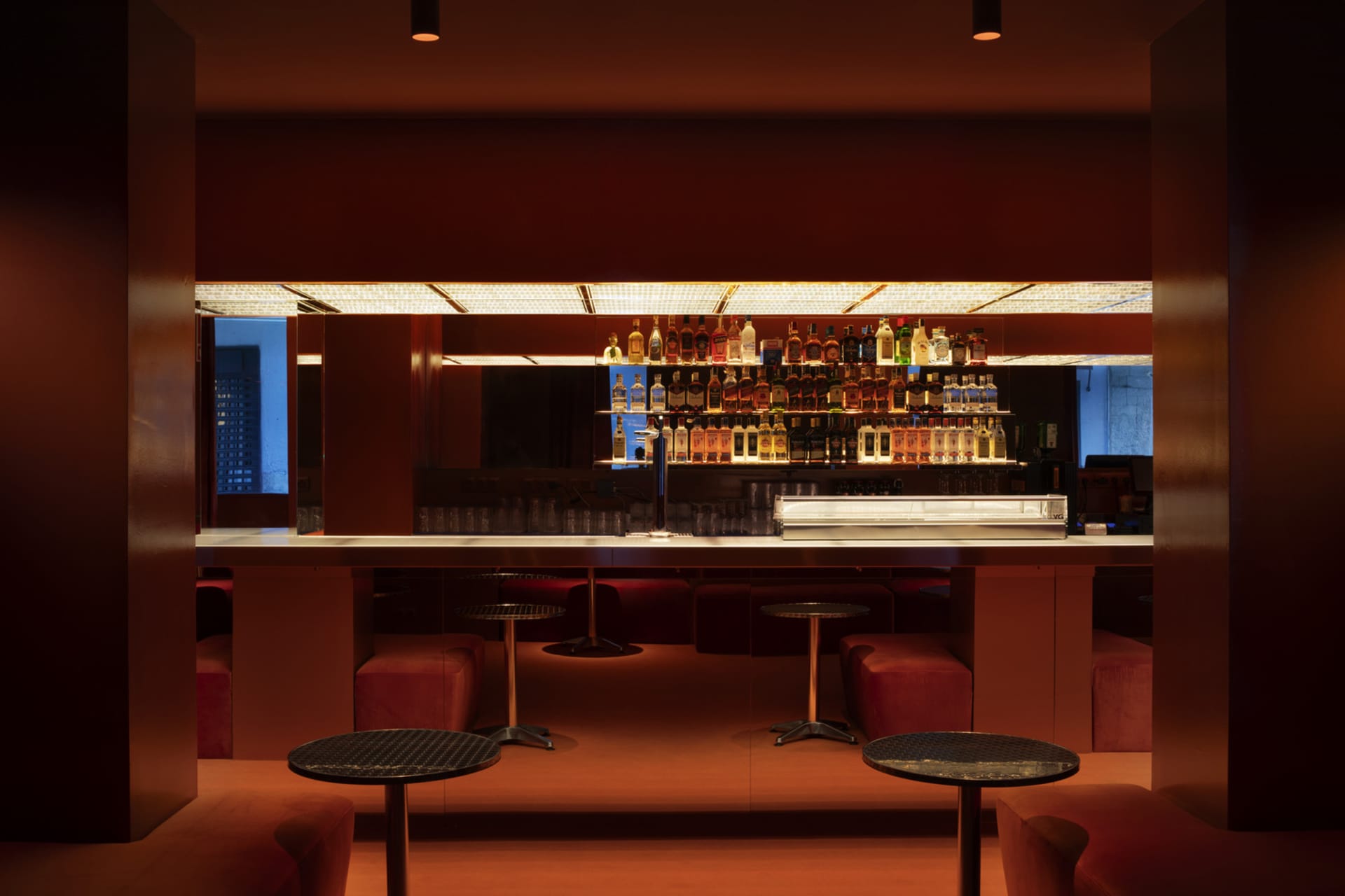 Industrial-style restaurant bar with metallic tables and barstools