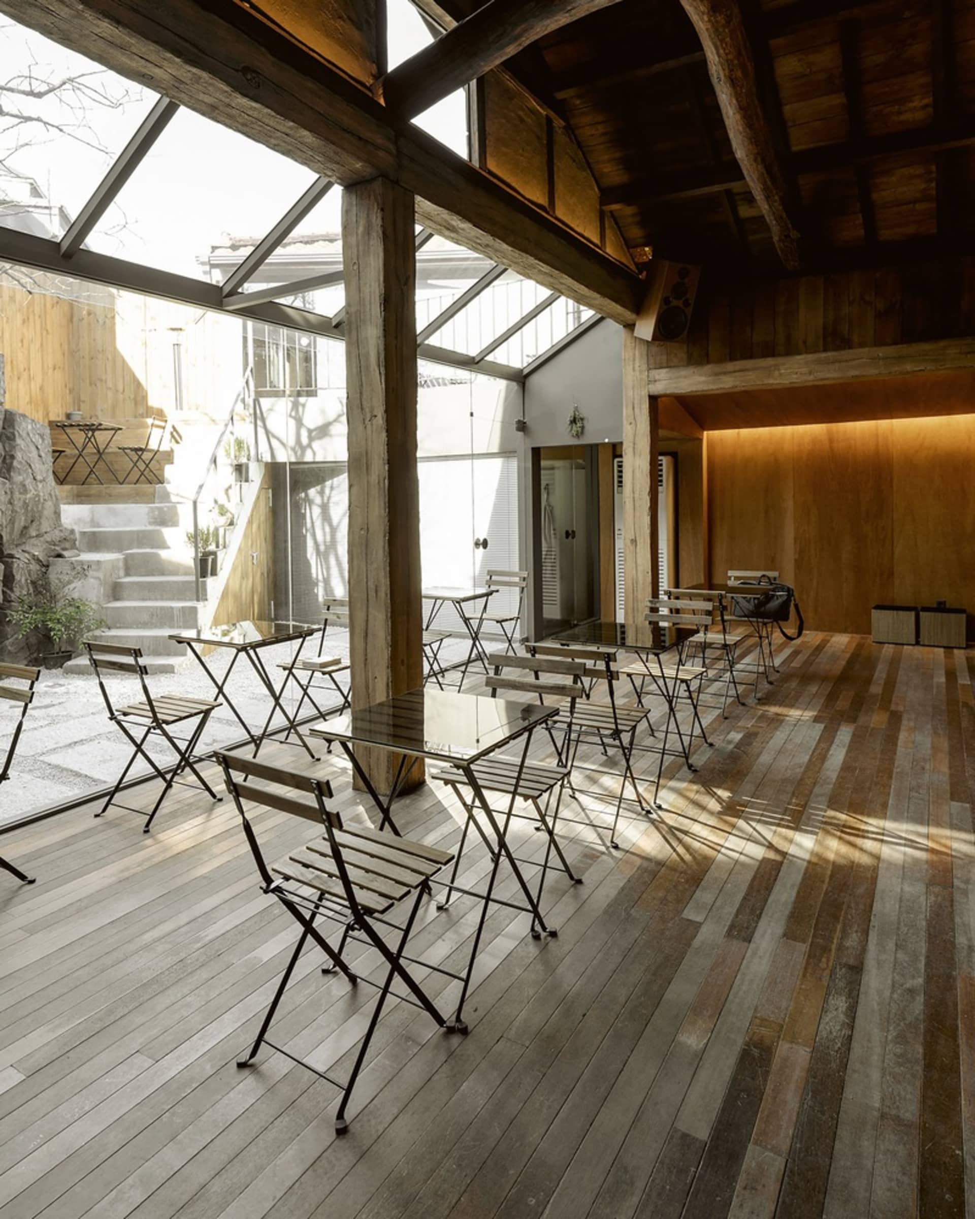 現代工業風餐廳室內,搭配木質家具與石材樓梯。