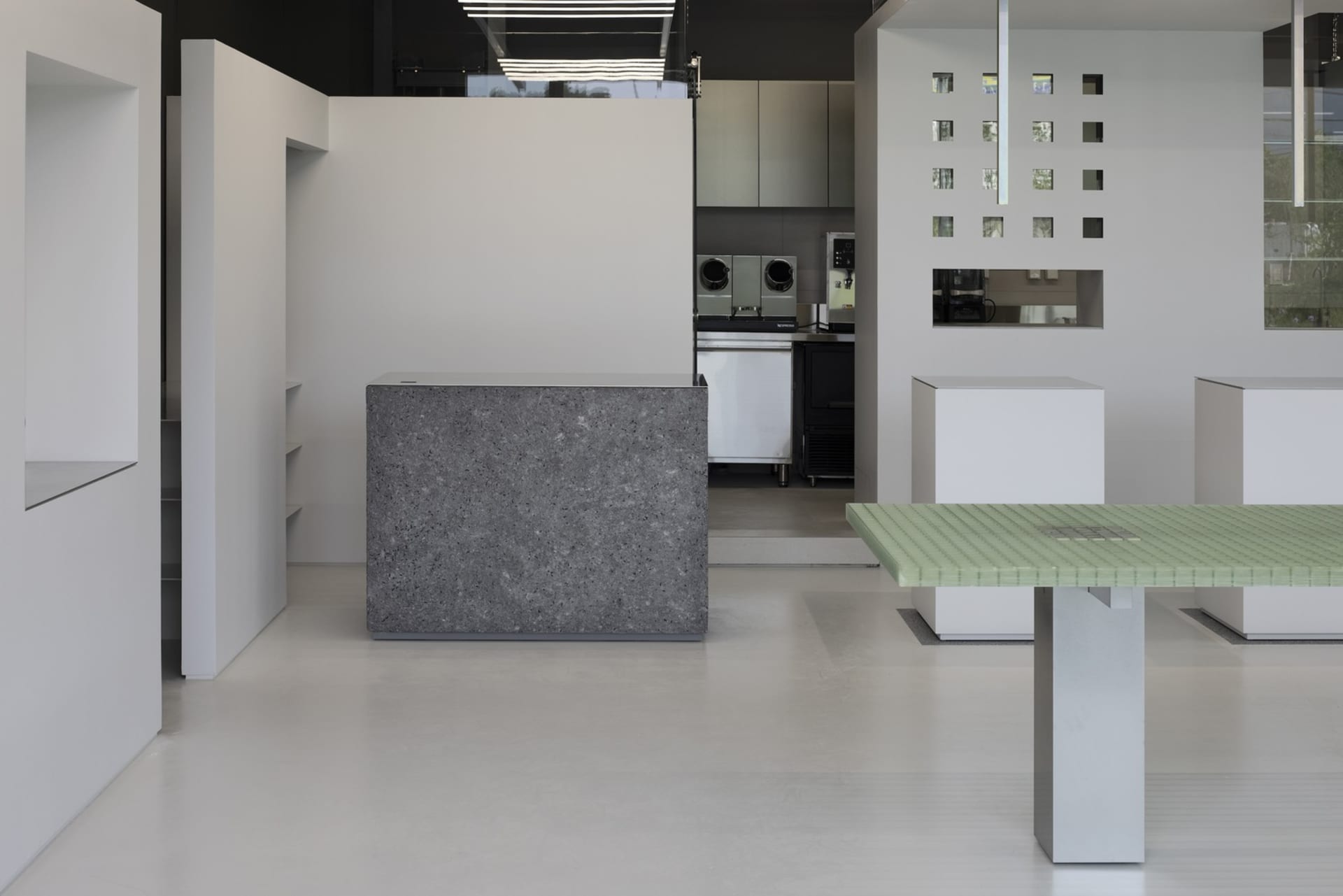 A minimalist coffee shop interior with a concrete counter