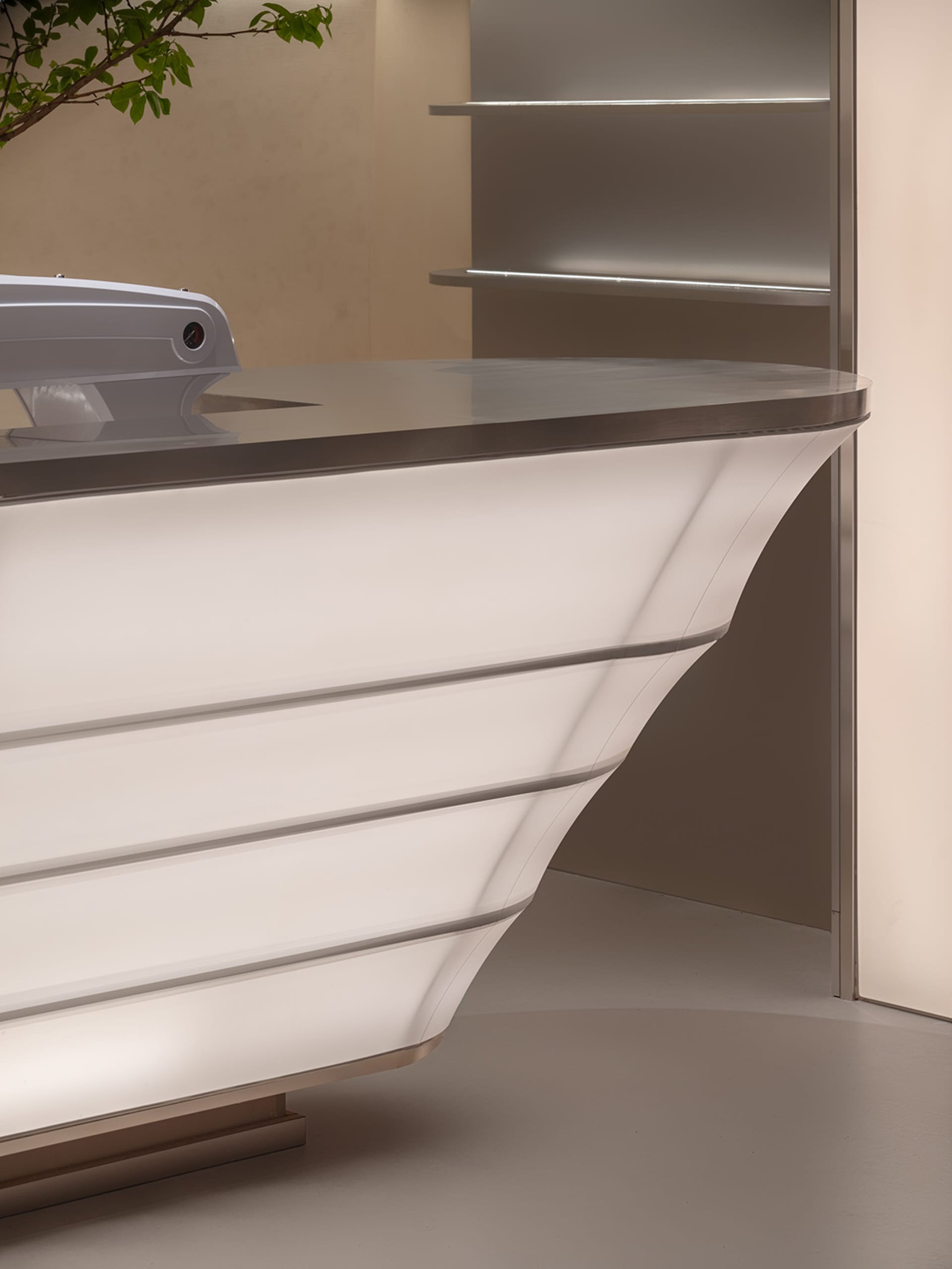 A sleek, modern reception desk with metallic surfaces and minimalist design.