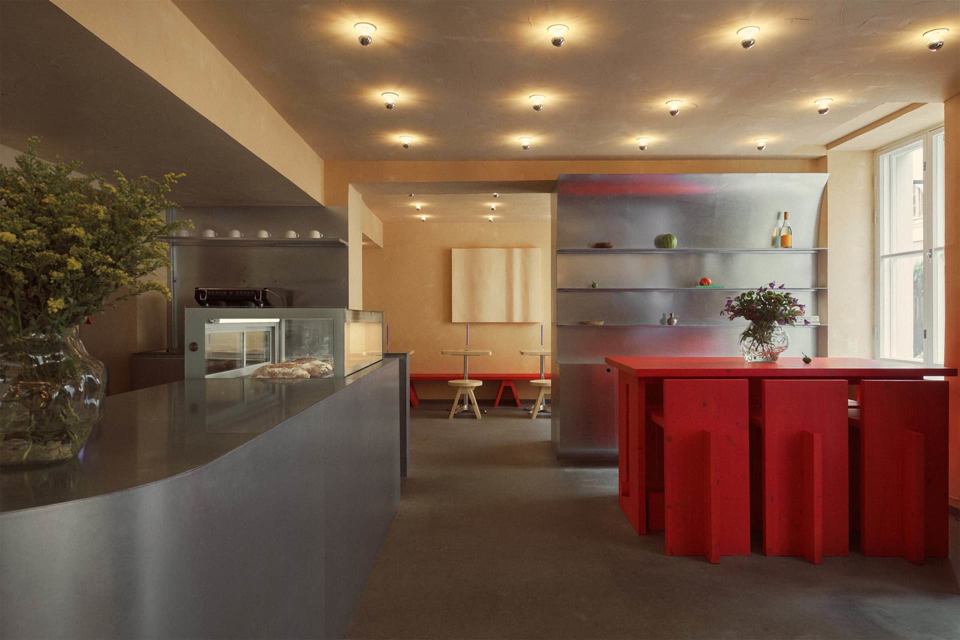 Modern restaurant interior featuring metallic surfaces and wooden elements.