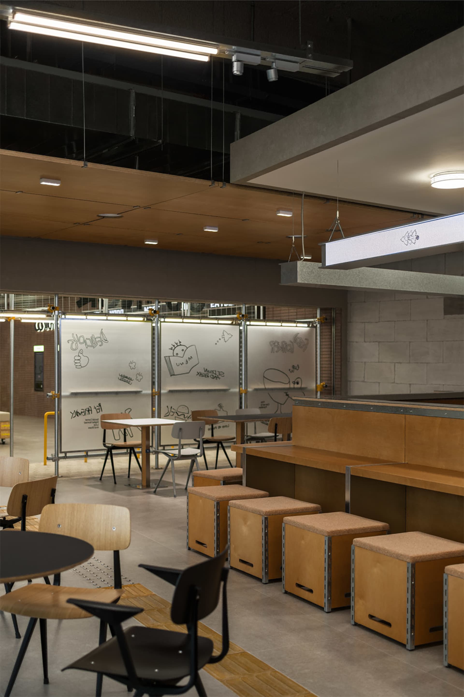A modern educational environment with industrial design elements and wooden furniture.