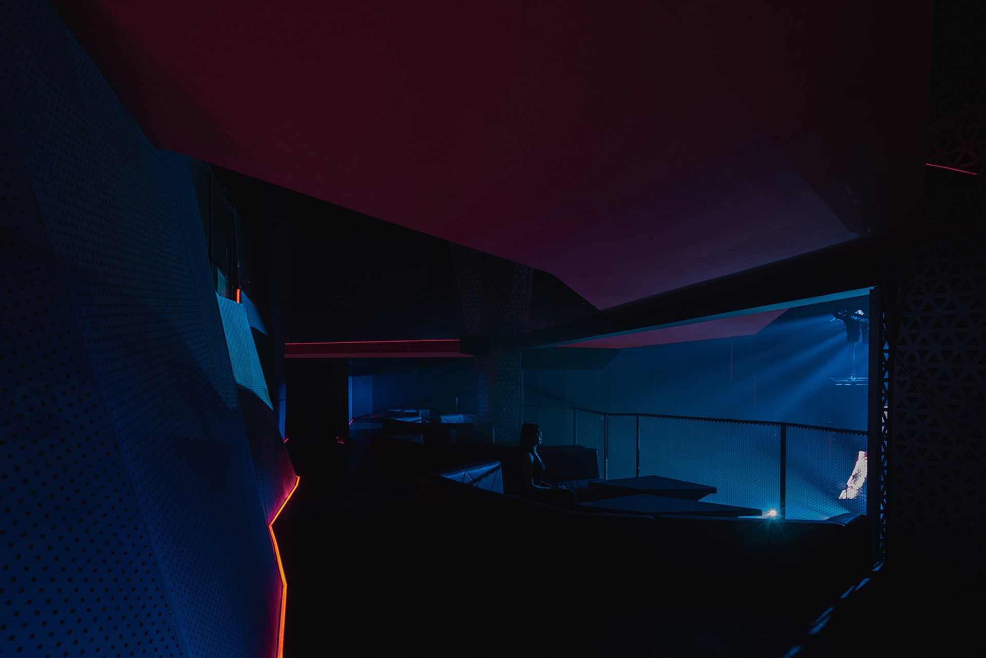 A modern nightclub with industrial design elements, featuring metal, glass, and concrete materials.