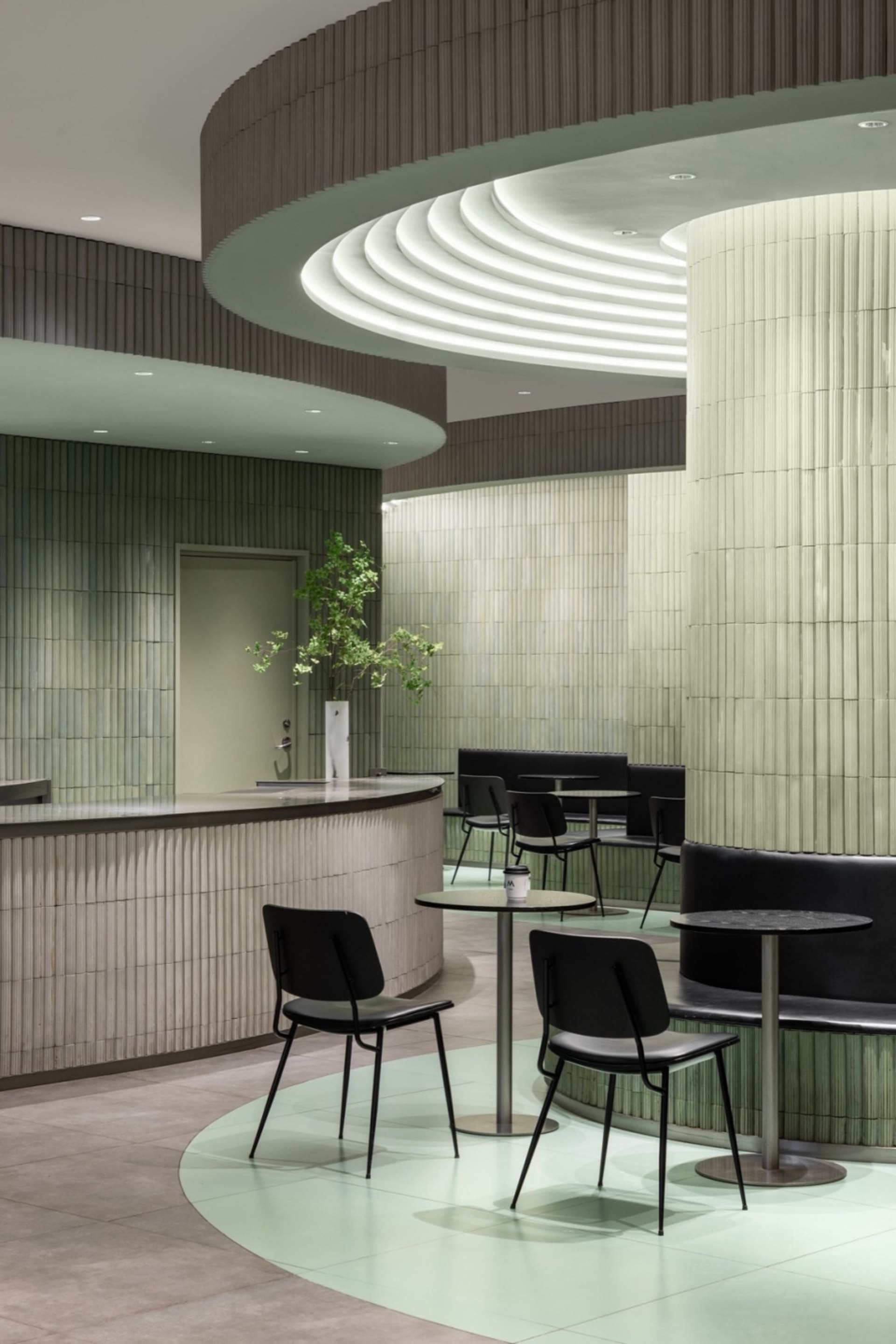 Modern cafe interior with pastel tiles and concrete design elements.