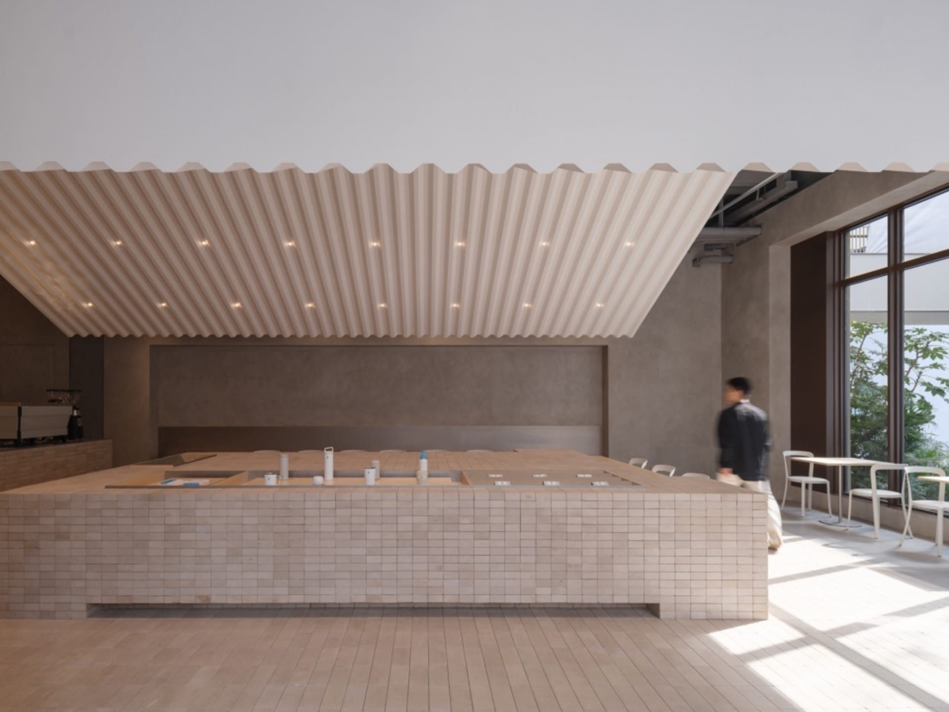 A contemporary-style coffee shop counter with a combination of concrete and tiled surfaces.
