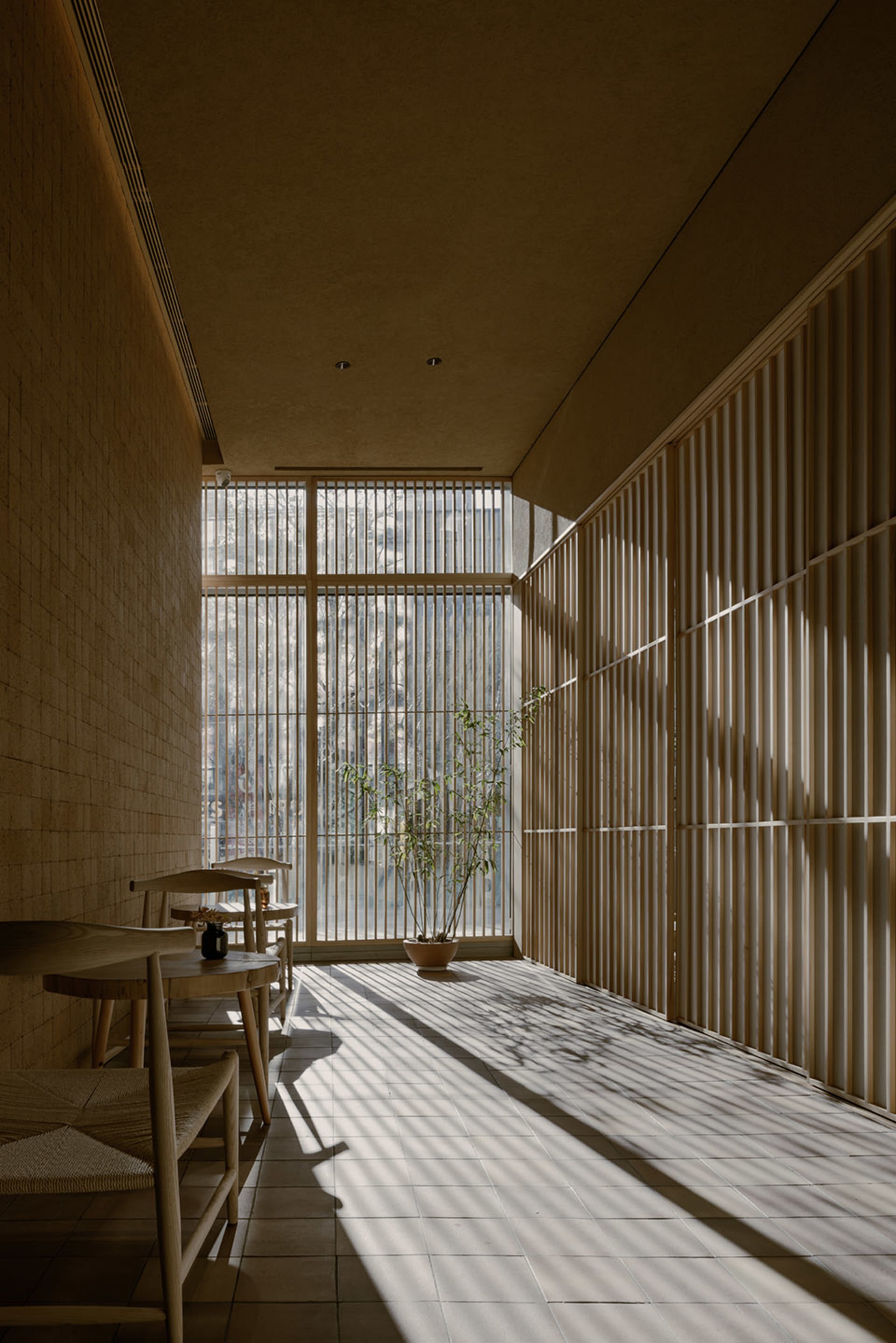 A modern restaurant interior with clear glass walls and wooden elements.